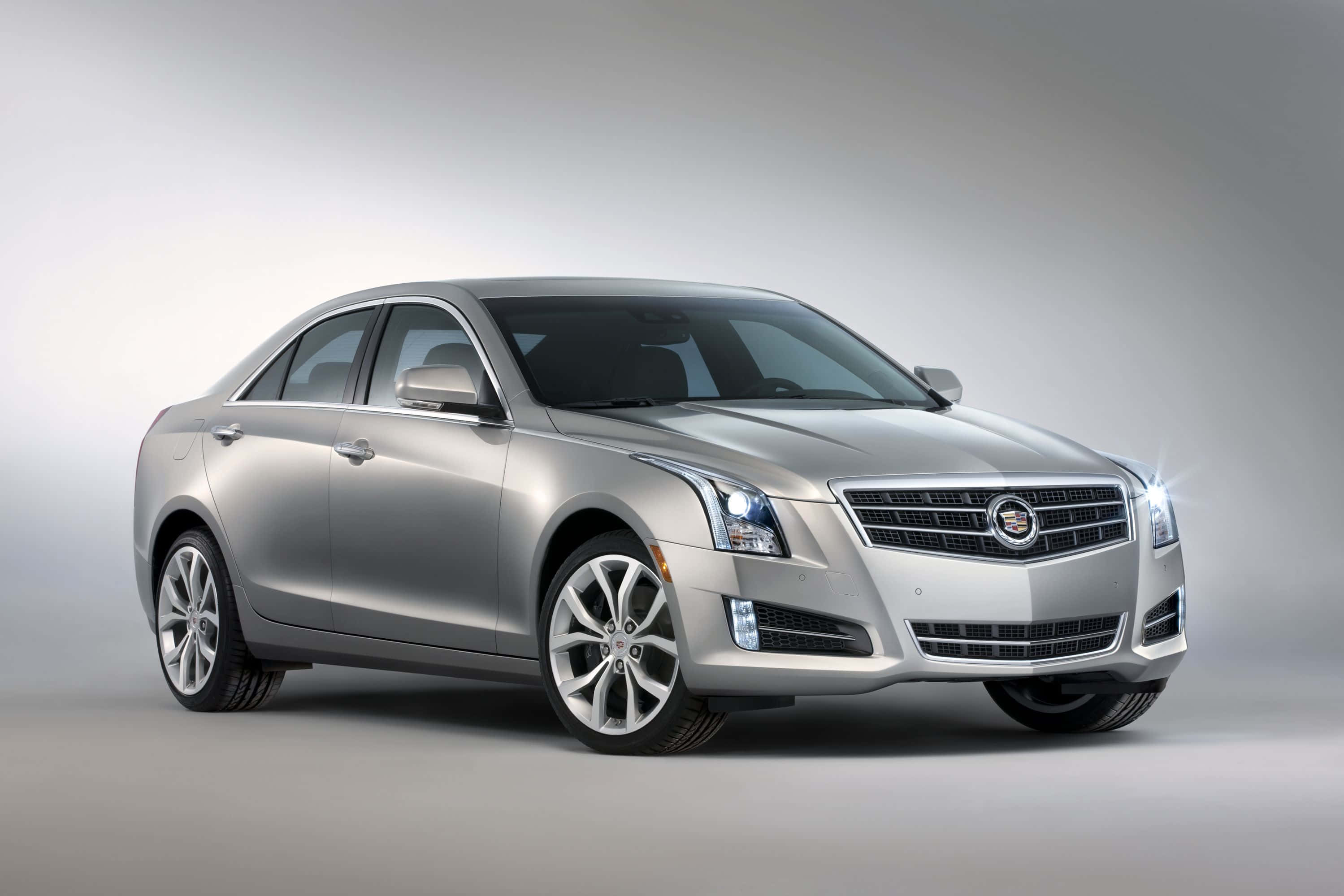 Cadillac Ats 桌布 壁紙 — 一輛時尚的銀色Cadillac ATS轎車在攝影棚燈光下閃耀，線條銳利，合金輪圈拋光。