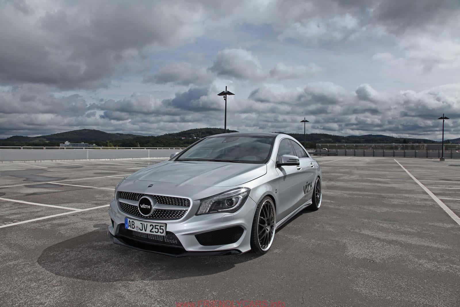 Mercedes Benz Cla-class 桌布 壁紙 — 一架時尚的銀色Mercedes-AMG CLA45停泊在空蕩蕩的瀝青停車場，上方是戲劇性的多雲天空。