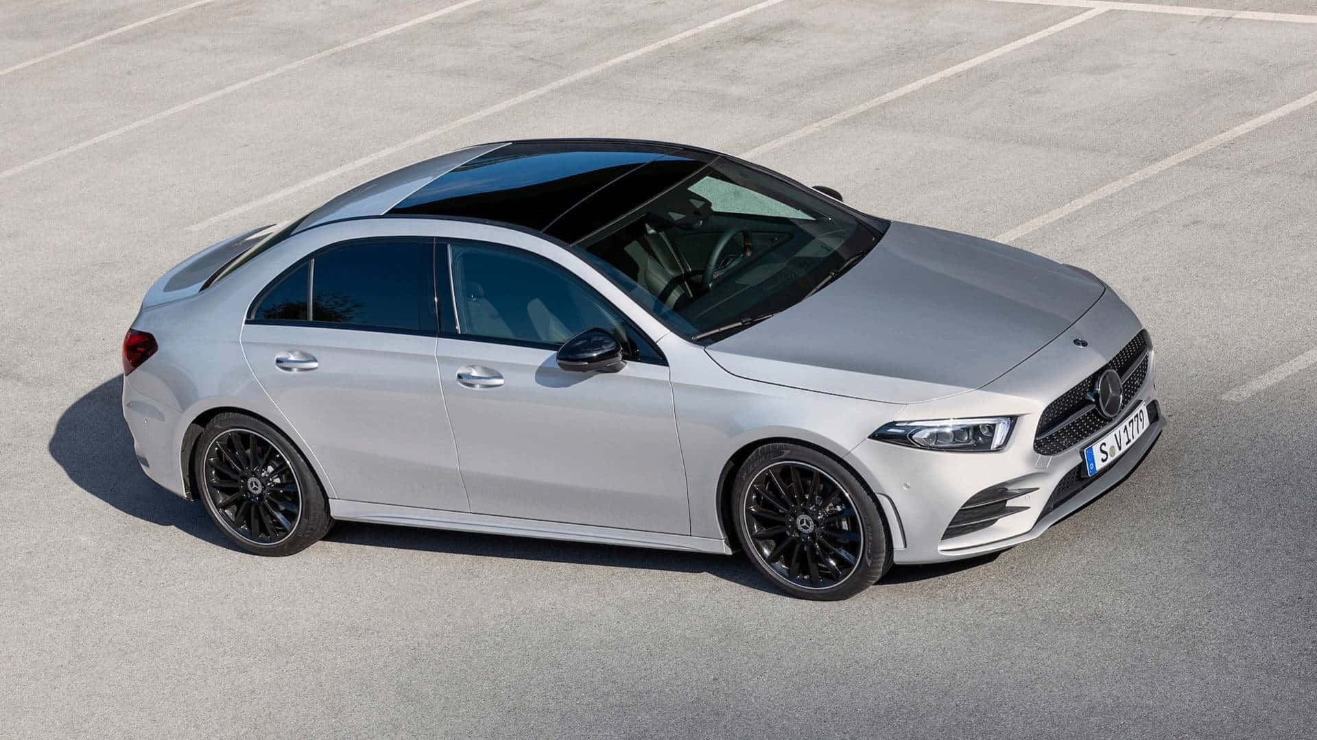 Mercedes Benz A-class 桌布 壁紙 — 一輛時尚的銀色梅賽德斯-奔馳轎車，帶有黑色飾邊，停在明亮的日光下的混凝土停車場上。