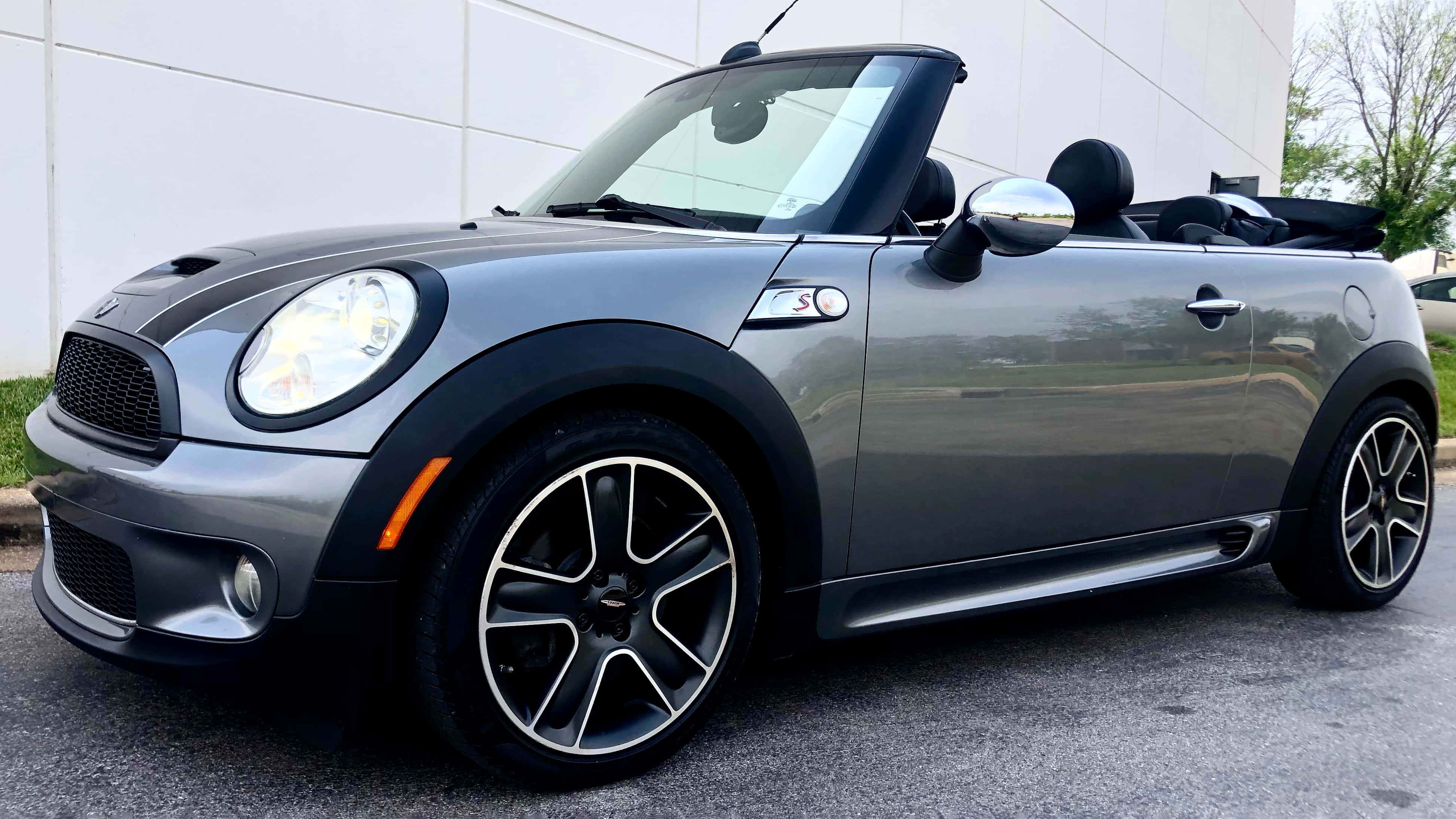 Mini Cooper S Convertible 桌布 壁紙 — 一架時尚的銀色MINI Cooper開篷車停在瀝青路上，背景有白色建築物和綠色樹木。
