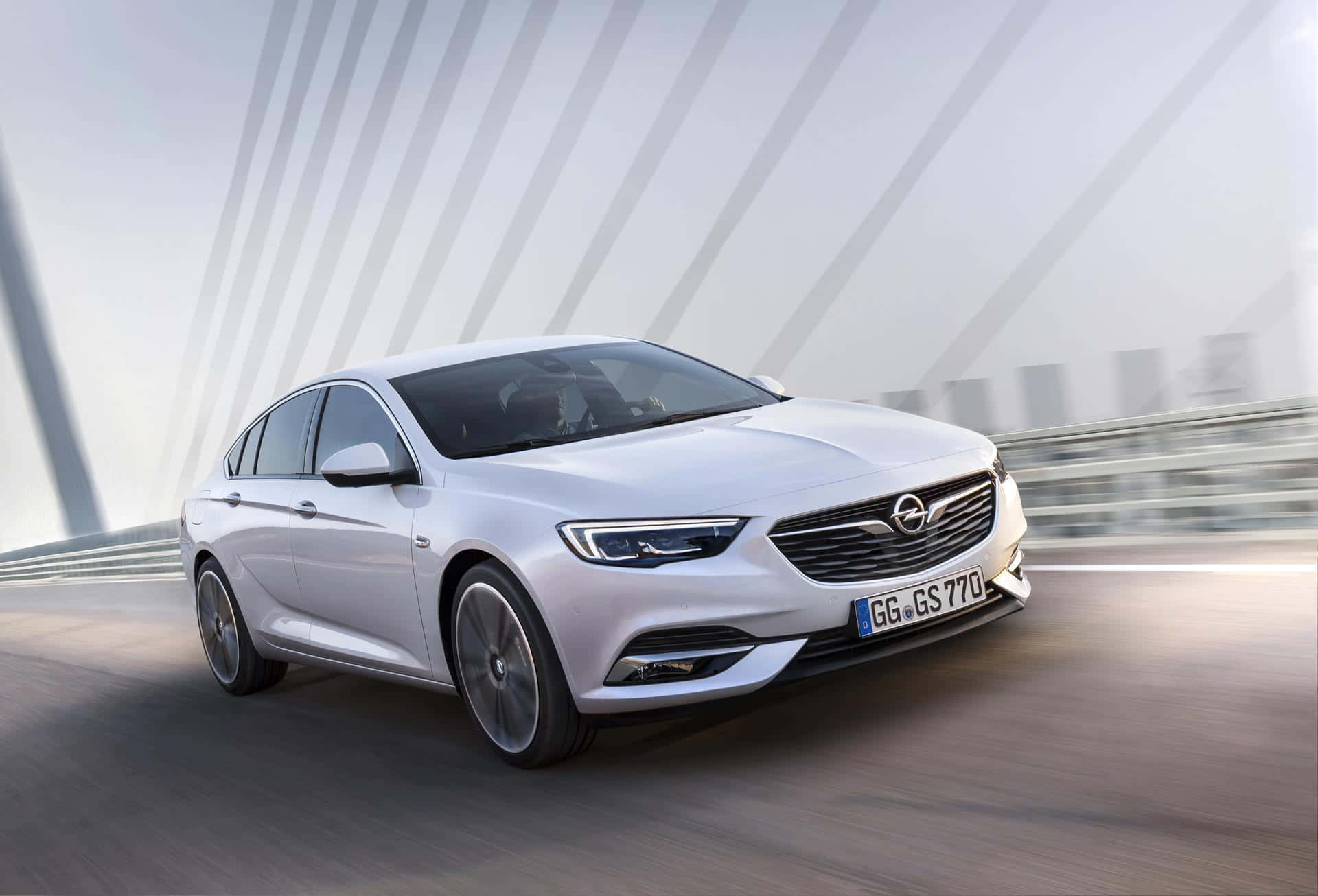 Opel Insignia 桌布 壁紙 — 一輛時尚的銀色轎車在現代橋樑上疾馳，動態模糊強調其動感。