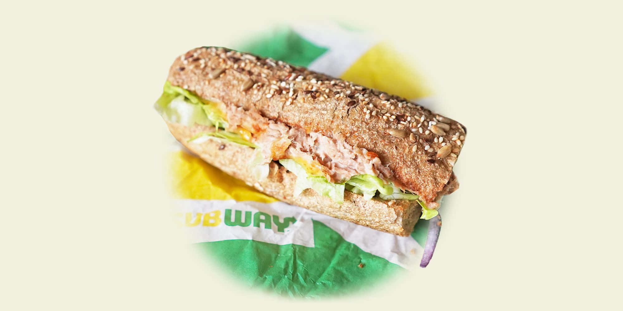 Subway 桌布 壁紙 — Subway 三文治嘅特寫，有芝麻麵包同新鮮配料，放喺品牌紙上面。