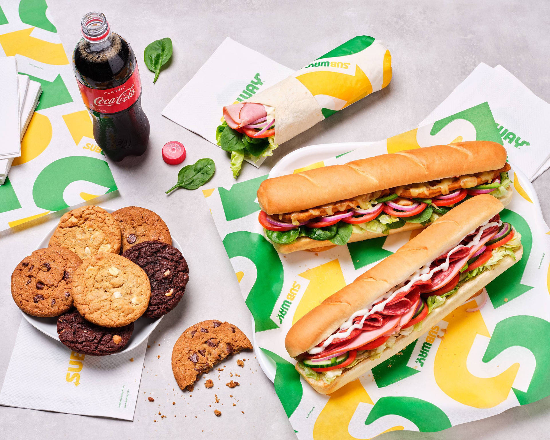 Subway三文治、曲奇餅和可口可樂放在品牌紙上。