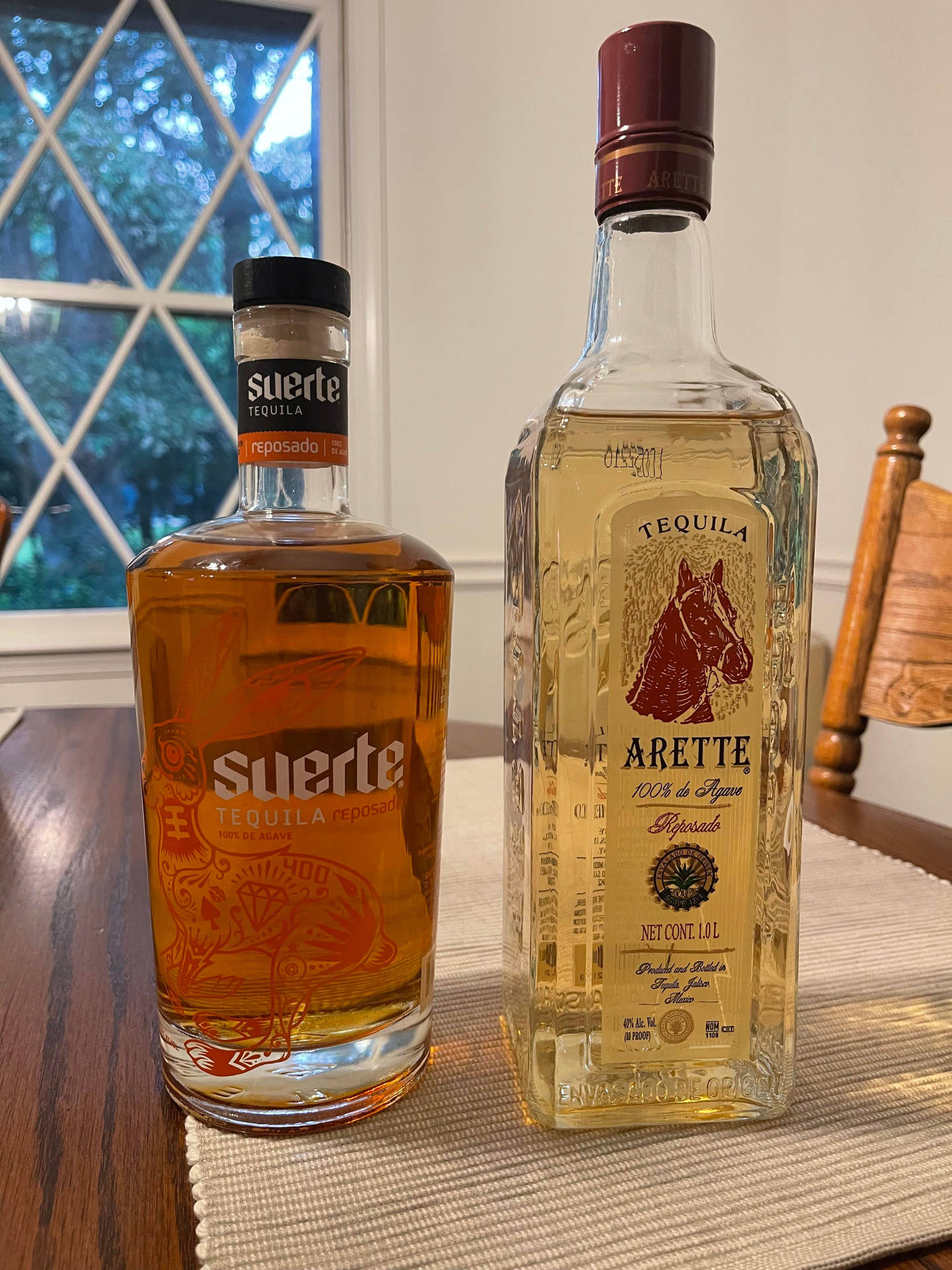 兩瓶 tequila 放在靠近菱形窗格的木桌上。