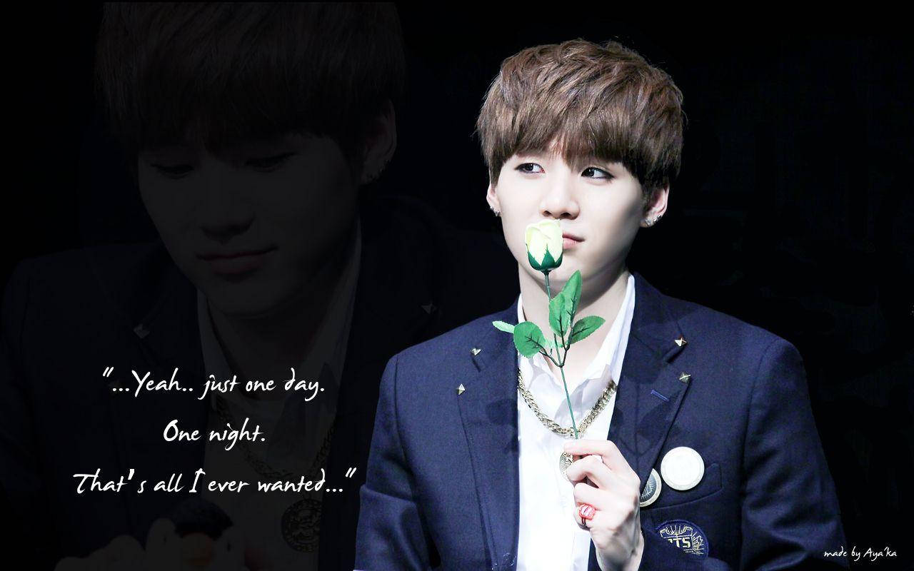 Suga BTS《Just One Day》 壁紙 — 一位身穿深色西裝的年輕男子，在黑色背景上將一朵白玫瑰放在唇邊，背景中有他自己褪色的雙重曝光影像。