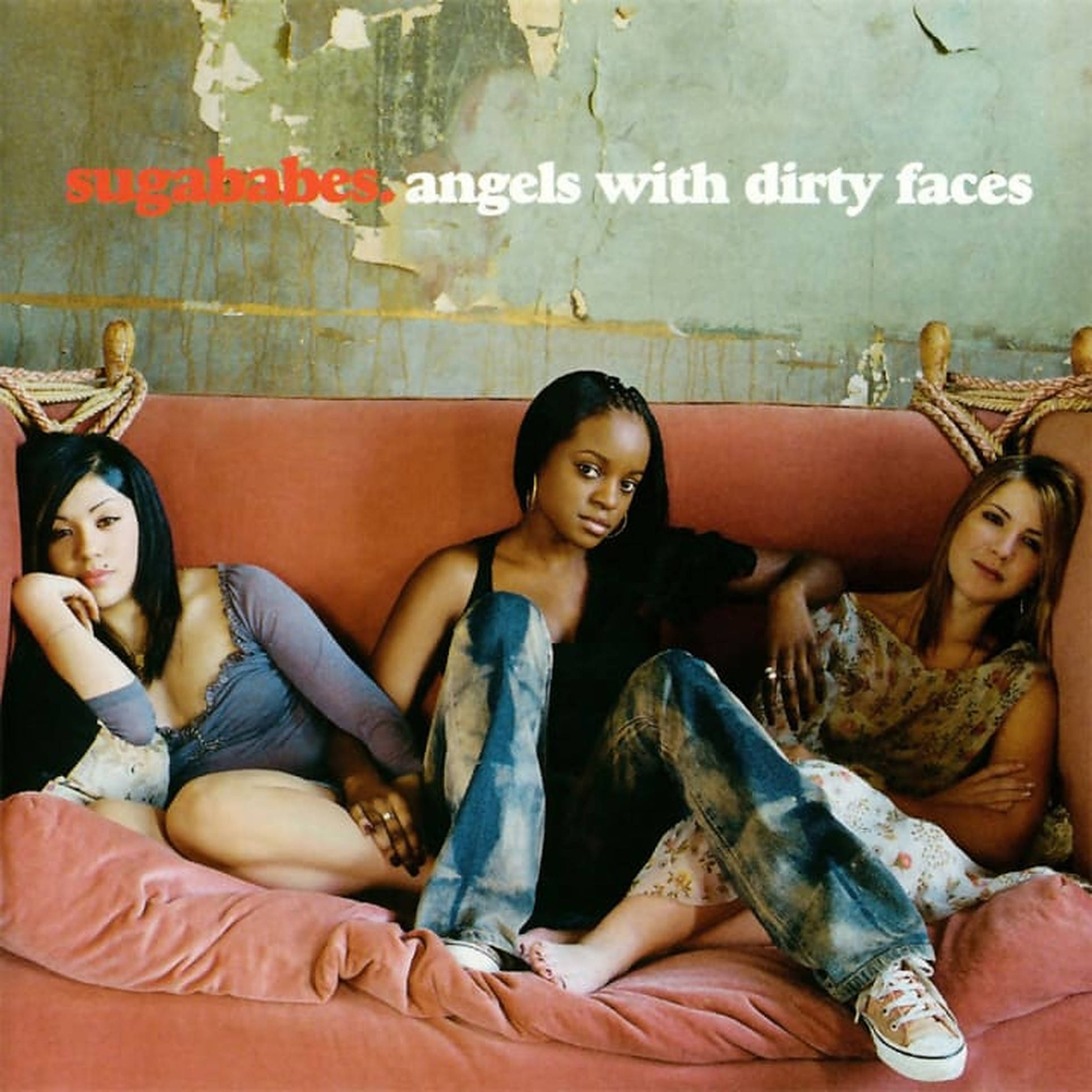 Sugababes《Angels With Dirty Faces》專輯封面 壁紙 — 三位女士隨意地躺在一張褪色的粉紅色沙發上，背景是剝落的綠色牆壁，上方有粗體專輯文字。