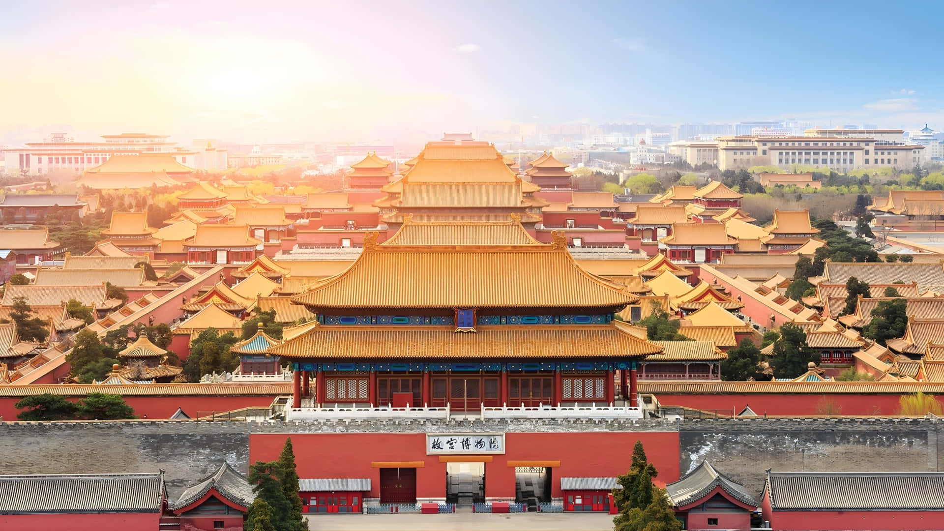  壁紙 — 陽光沐浴著故宮雄偉的金色屋頂和紅色城牆，散發出溫暖的光芒。