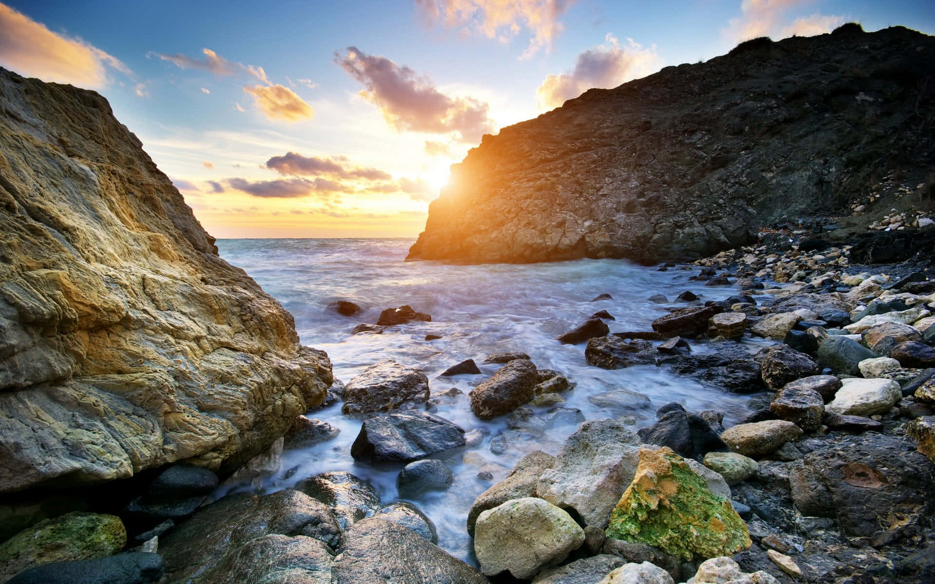 夕陽映照岩石海岸，海浪拍岸。