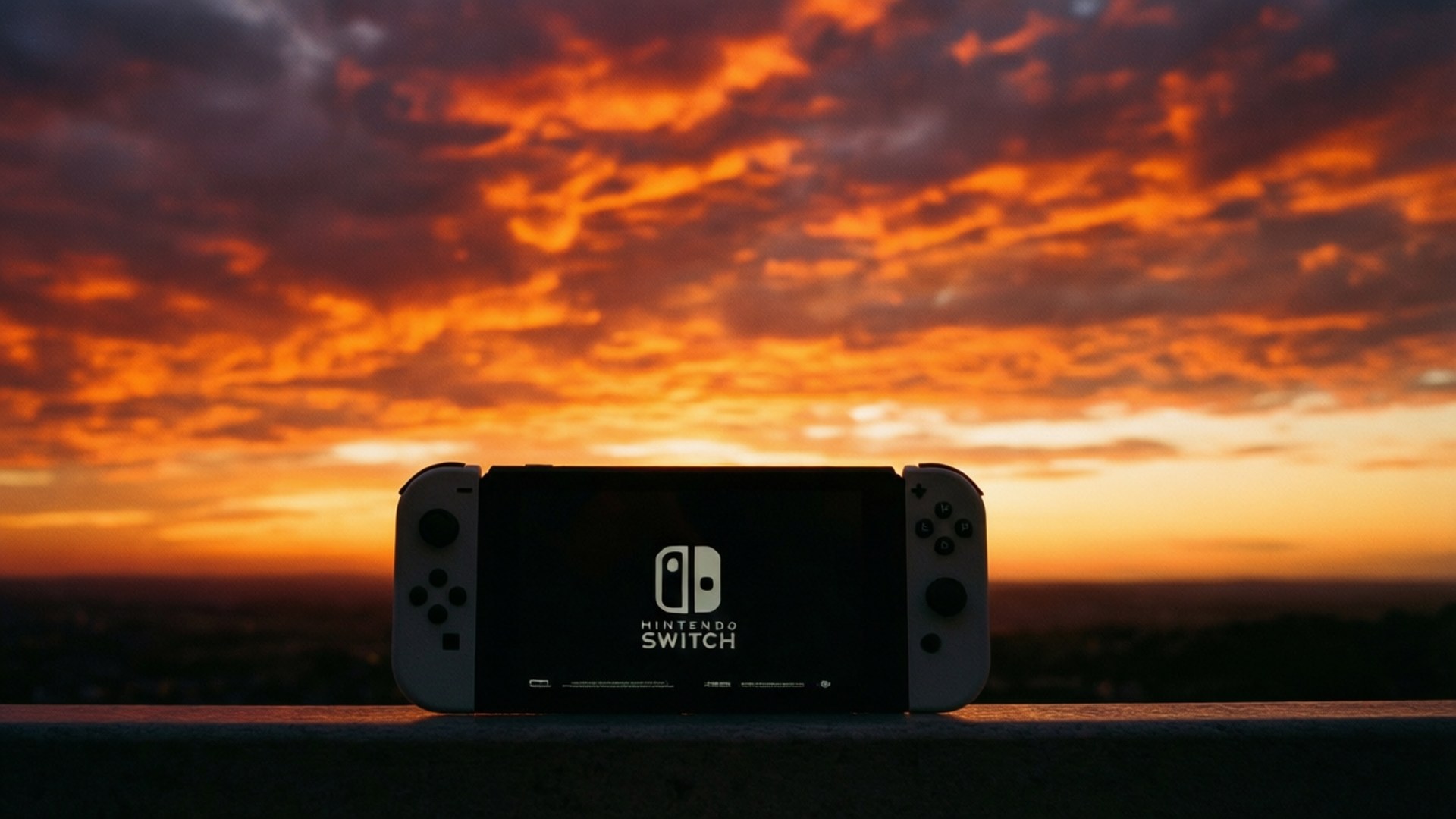 Sunset Silhouette 壁紙 — 一部 Nintendo Switch 主機以剪影形式出現在火熱的橙色和紫色日落天空前。