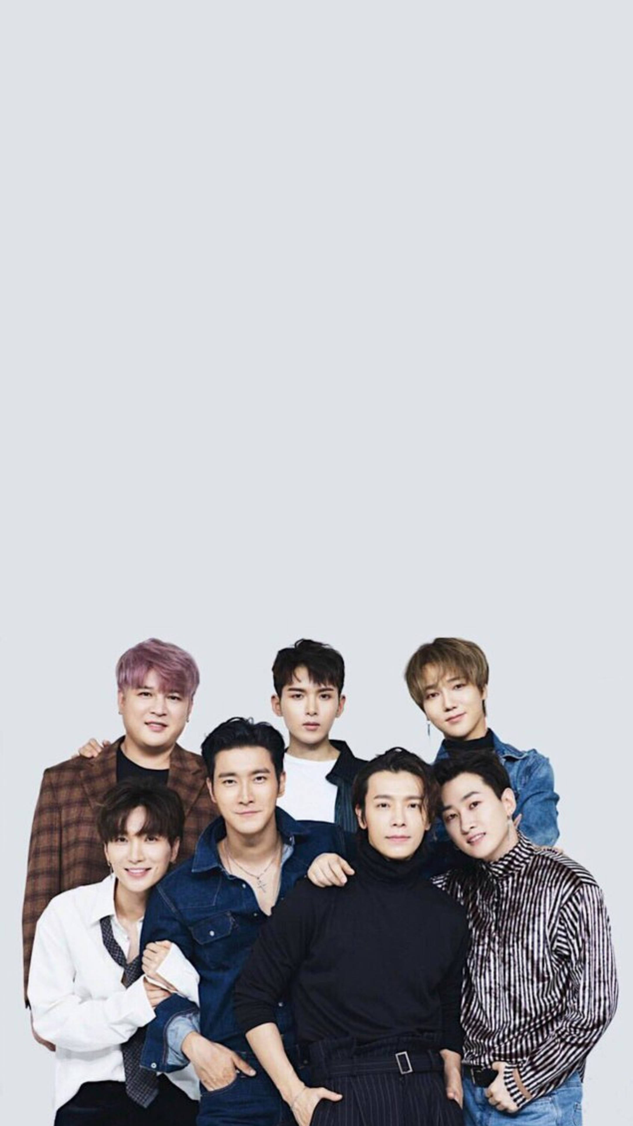Super Junior 七人合照 壁紙 — 七位時尚男士穿著休閒服裝，在純淺灰色背景前緊密擺姿勢，表情自信。