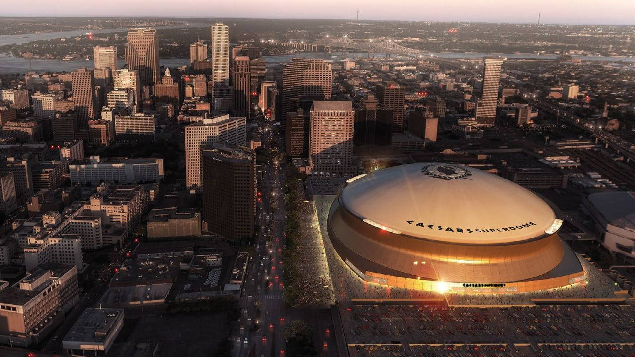 紐奧良 Superdome 的空中拍攝 壁紙 — 凱撒超級巨蛋在黃昏時分，在河流和橋樑環繞的廣闊城市天際線中閃耀的航拍視圖。