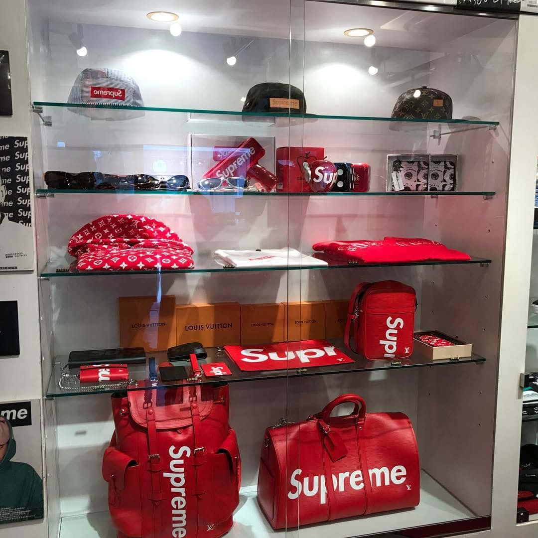 零售展示櫃，展示Supreme和Louis Vuitton品牌的紅色時尚物品。