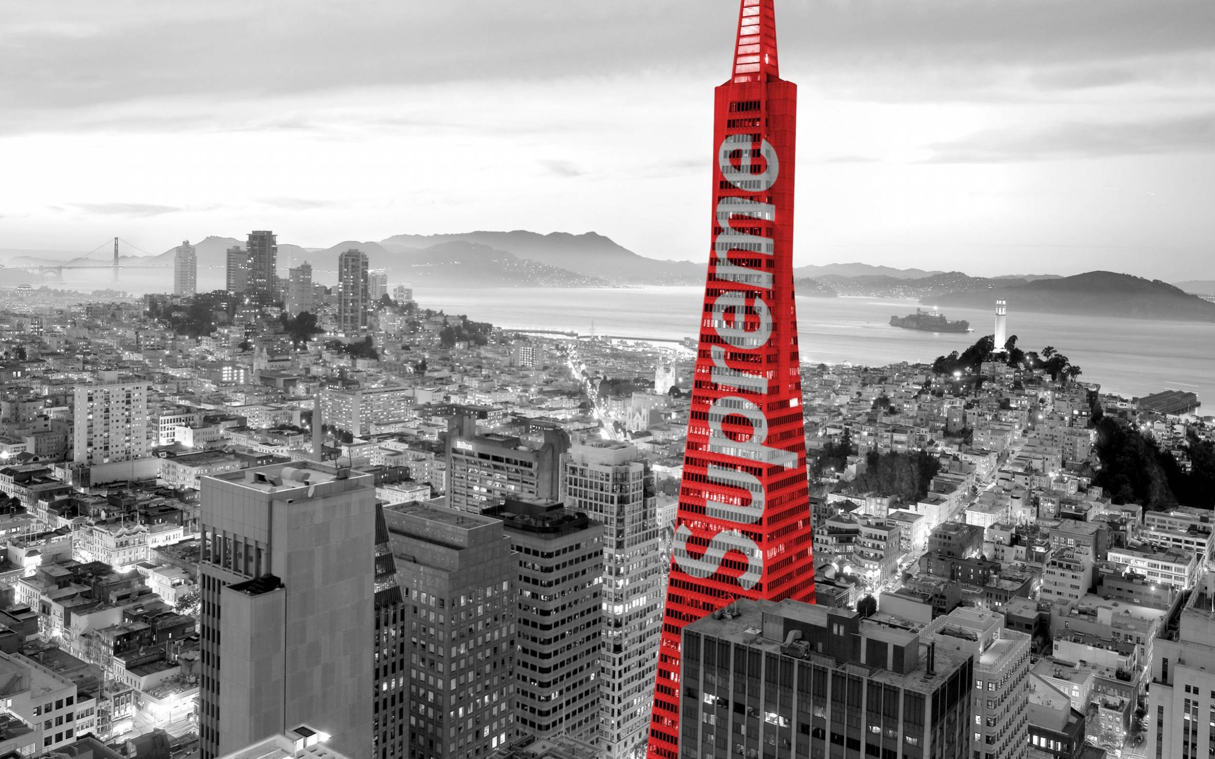 Supreme標誌於建築物 壁紙 — 一座引人注目的紅色摩天大樓帶有「Supreme」字樣，在黃昏時分主導了黑白舊金山的天際線。