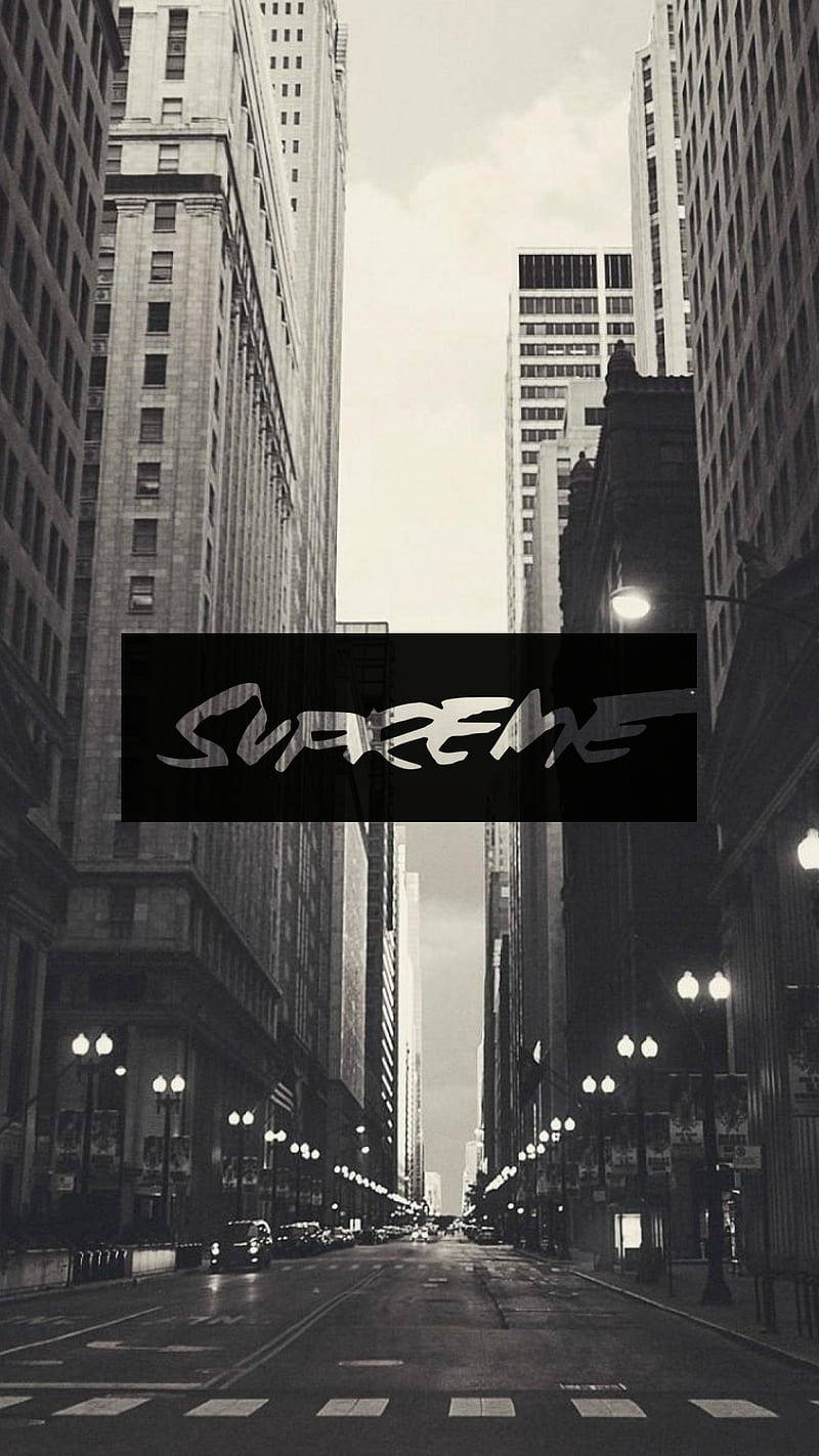 黑白城市街道，兩旁高樓大廈，中央有Supreme標誌。