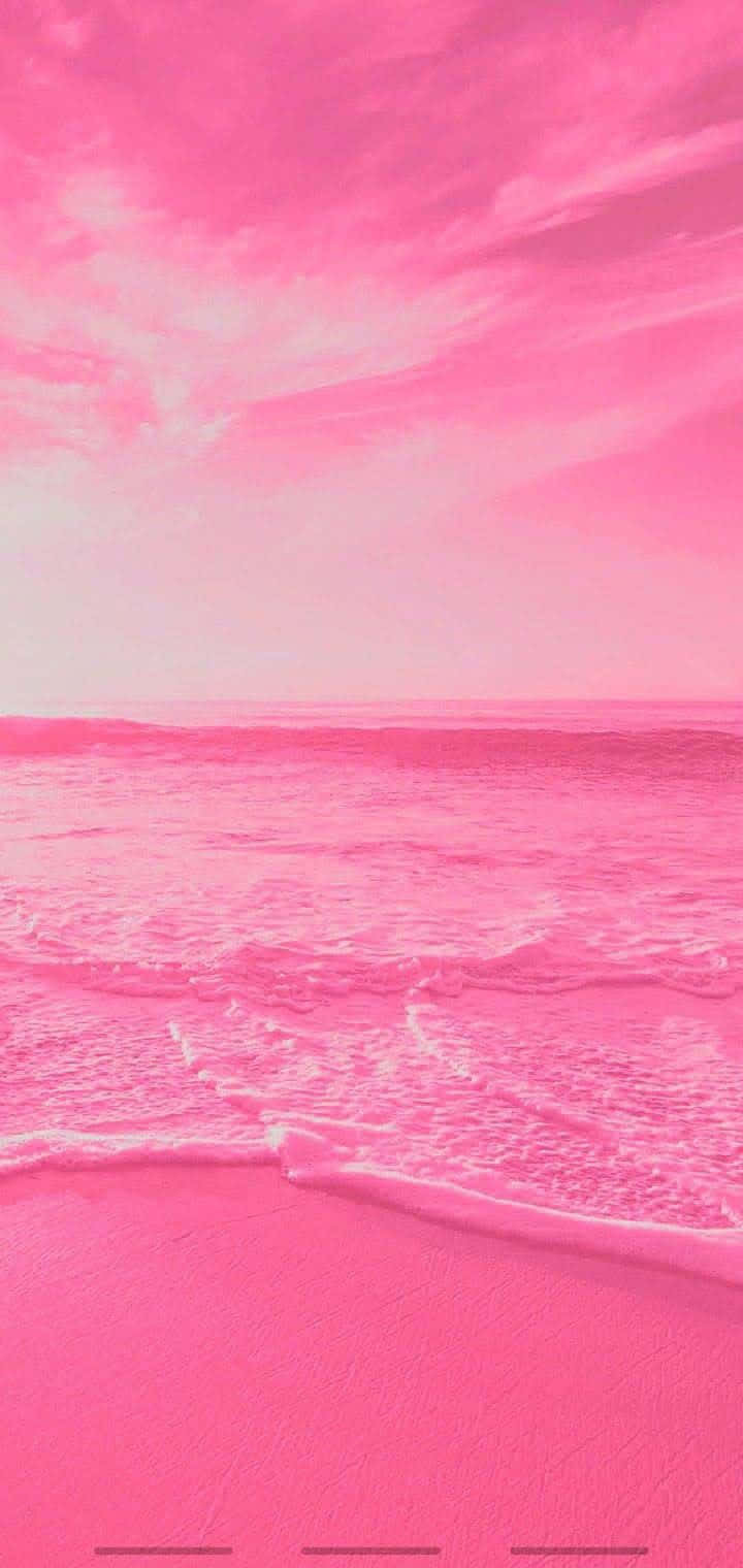  壁紙 — 超現實的粉紅色海灘場景，柔和的海浪在粉彩粉紅色的天空下輕輕拍打柔軟的沙灘。
