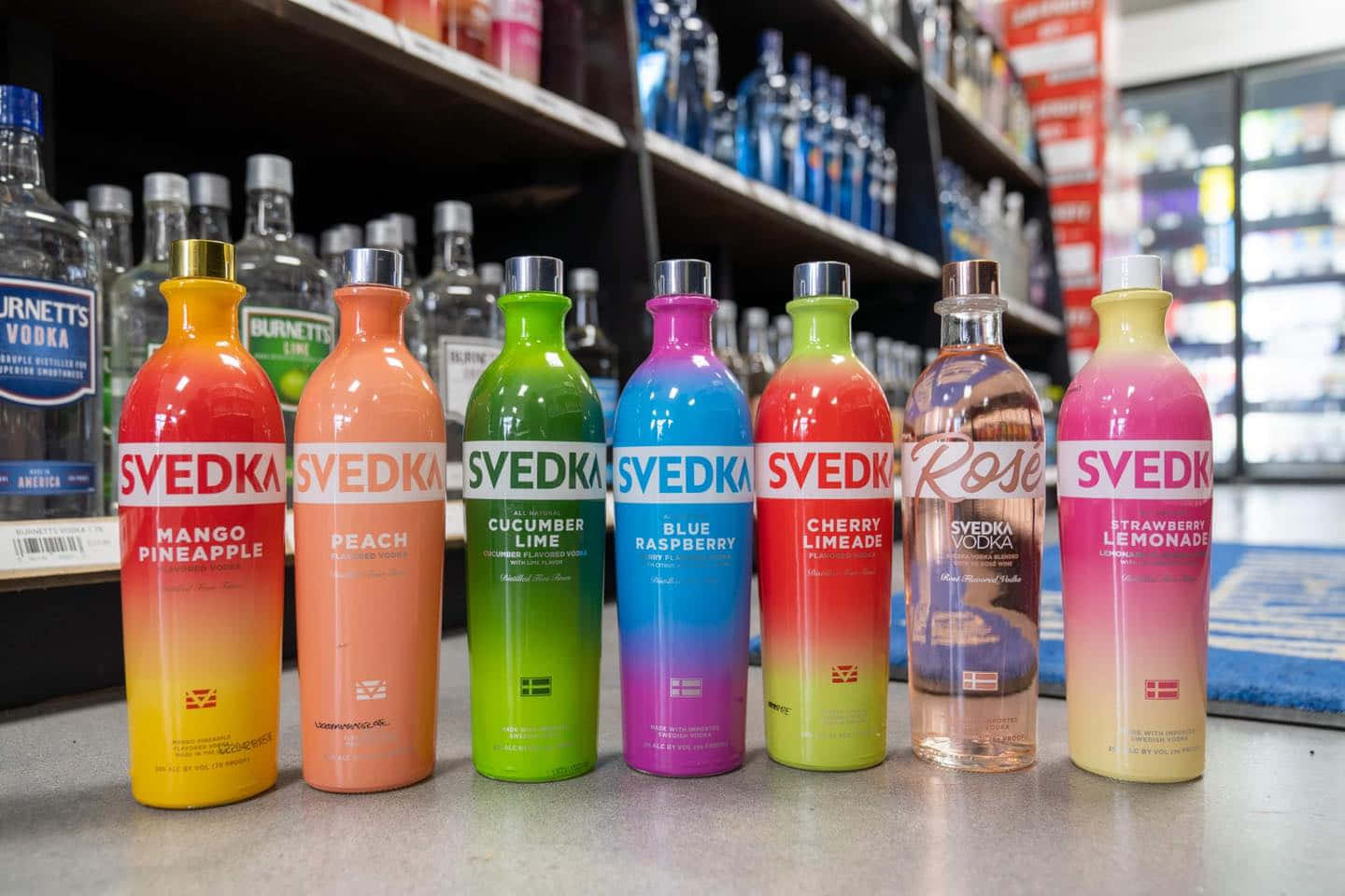 商店貨架上排列著一排色彩繽紛的Svedka伏特加酒瓶。