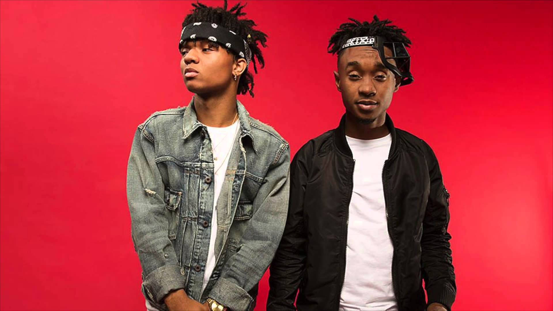 Swae Lee 與摯友 壁紙 — 兩名年輕男子梳著辮子頭、戴著頭帶，在鮮紅色的攝影棚背景前自信地擺姿勢。