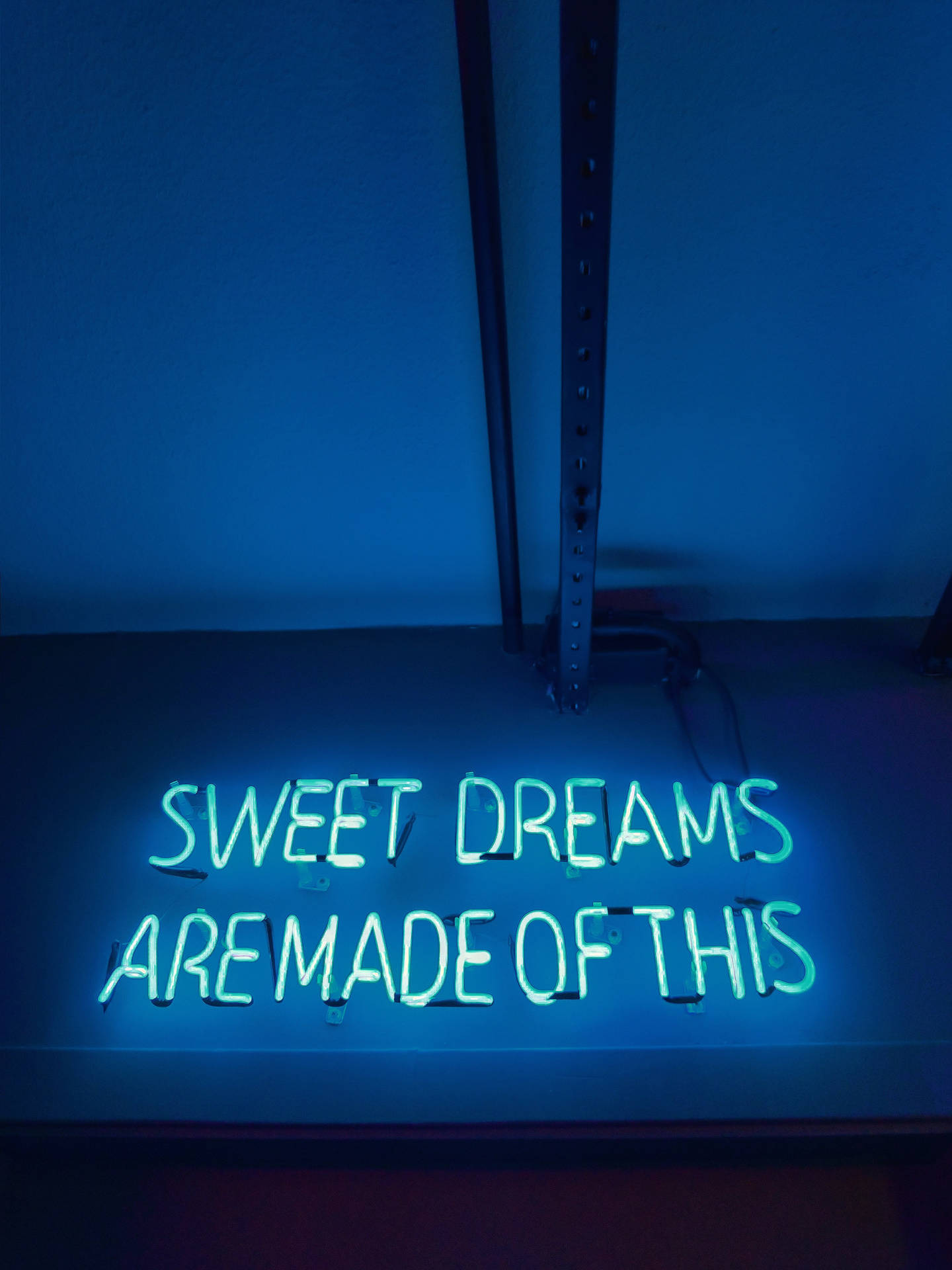 藍光中寫著 sweet dreams are made of this 的霓虹燈牌。