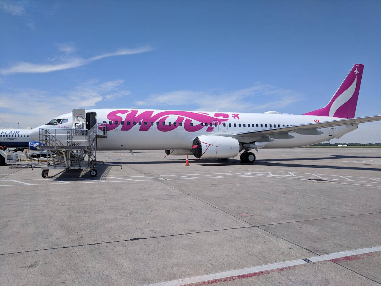 Swoop飛機停在機場閘口，連接了登機橋