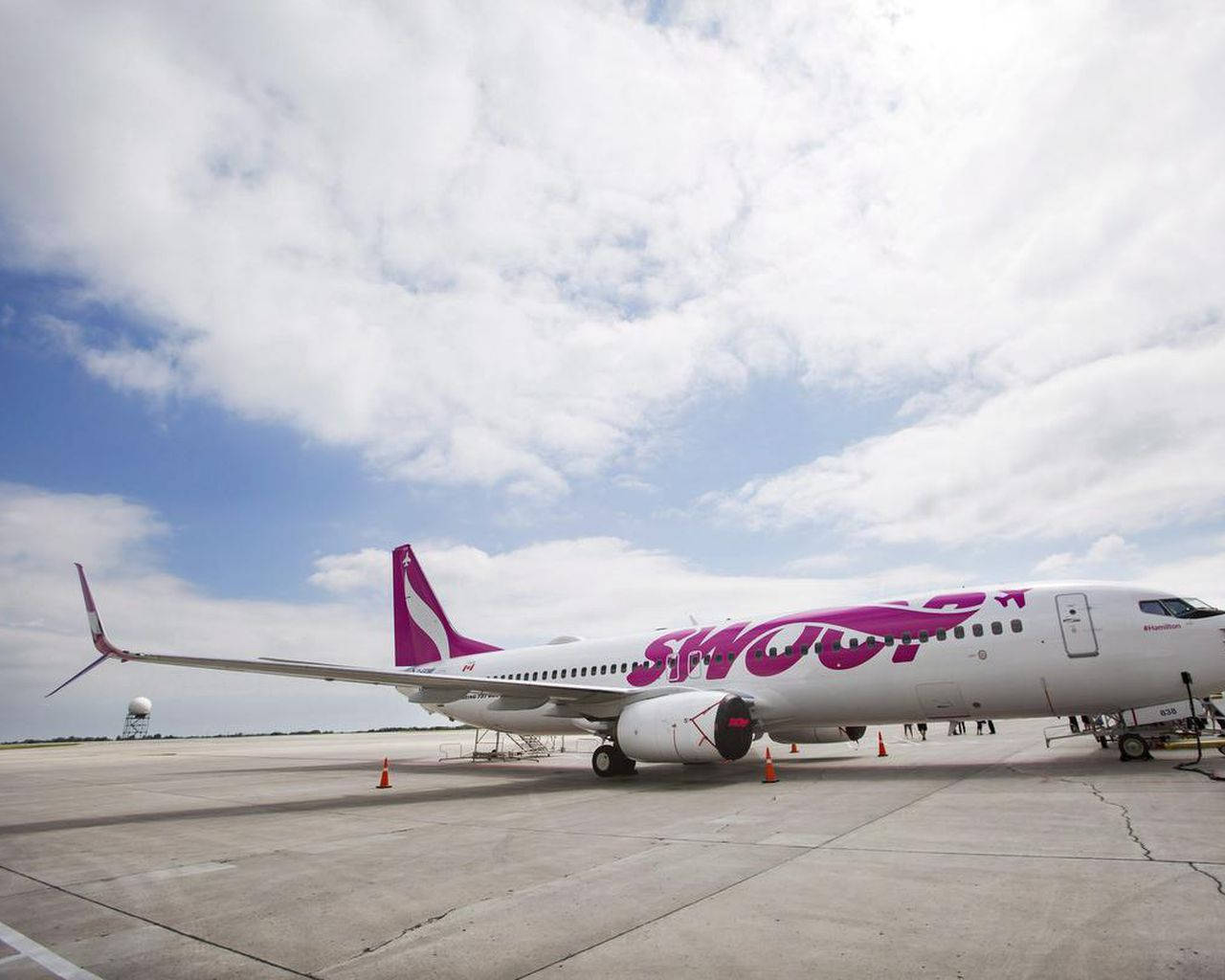 Swoop飛機停泊在機場停機坪上，天空多雲
