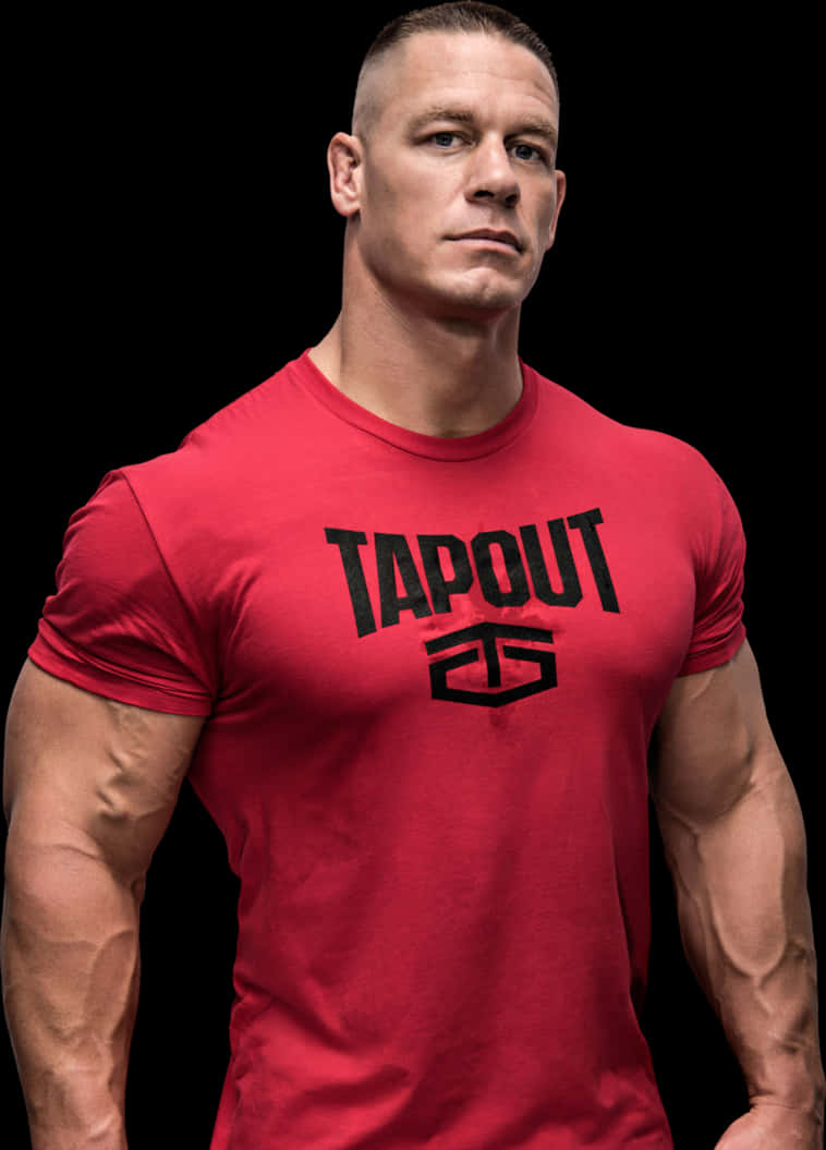 約翰·塞納紅色Tapout T恤 壁紙 — 一個肌肉發達的男人穿著紅色Tapout T恤，在黑色背景前專注地擺姿勢。