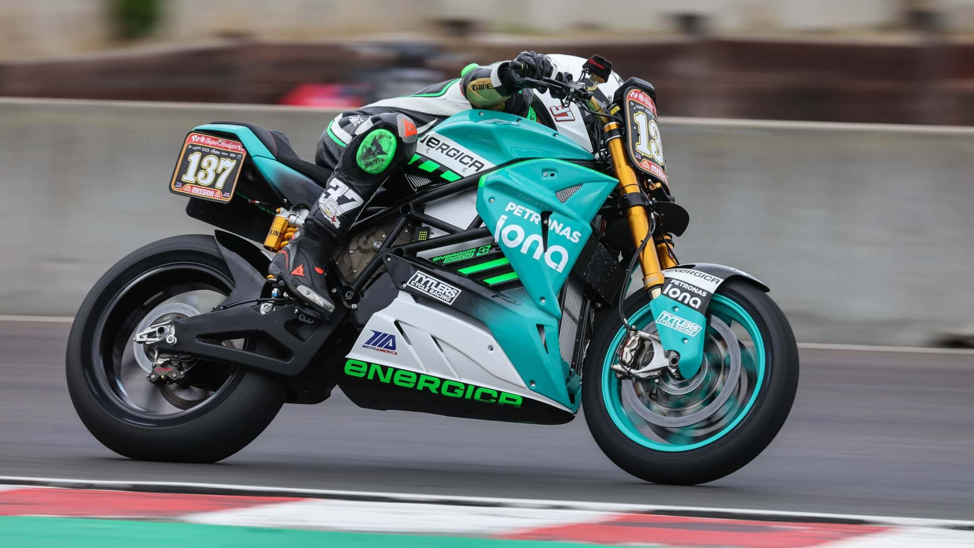  壁紙 — 一輛青綠色和白色的 Energica 電動電單車，車手編號 137，在紅白相間的路緣賽道上疾馳。