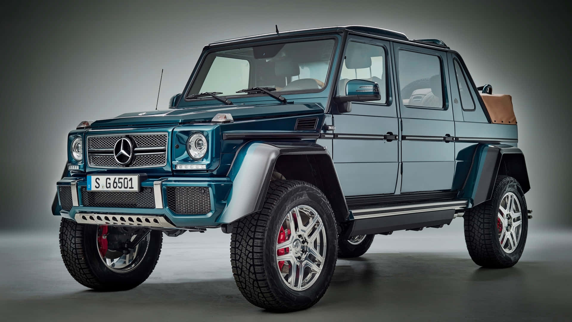  壁紙 — 一輛青綠色平治 G-Class SUV，配備紅色制動卡鉗和銀色輪圈，在漸變灰色背景的攝影棚中展示。