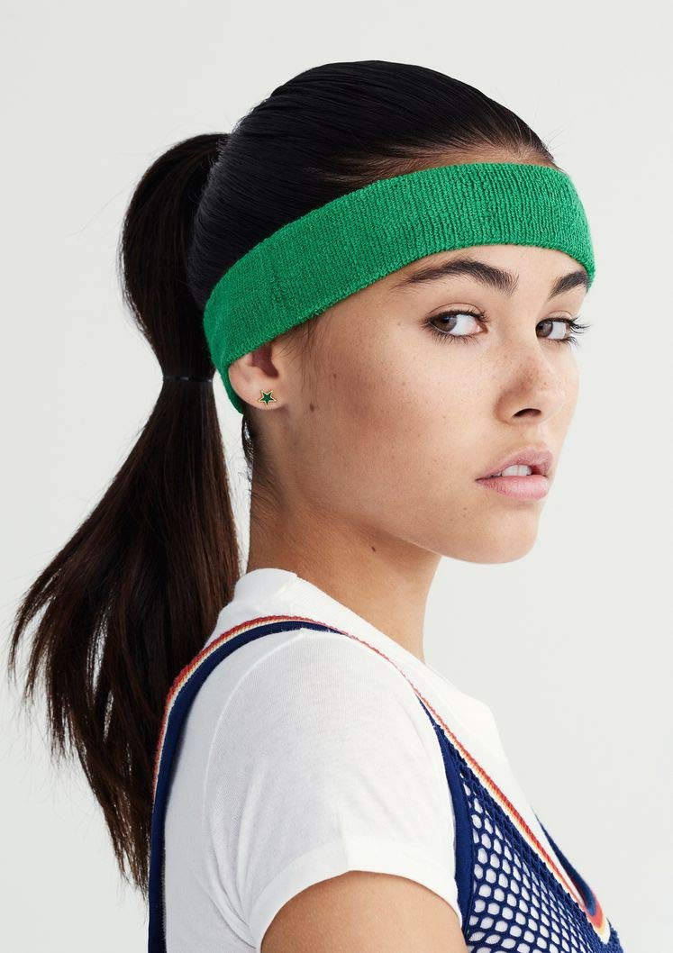 麥迪遜·比爾 Teen Vogue 專訪 壁紙 — 一位深色頭髮紮馬尾的女性，戴著亮綠色頭帶和星星耳環，背景為純白色。