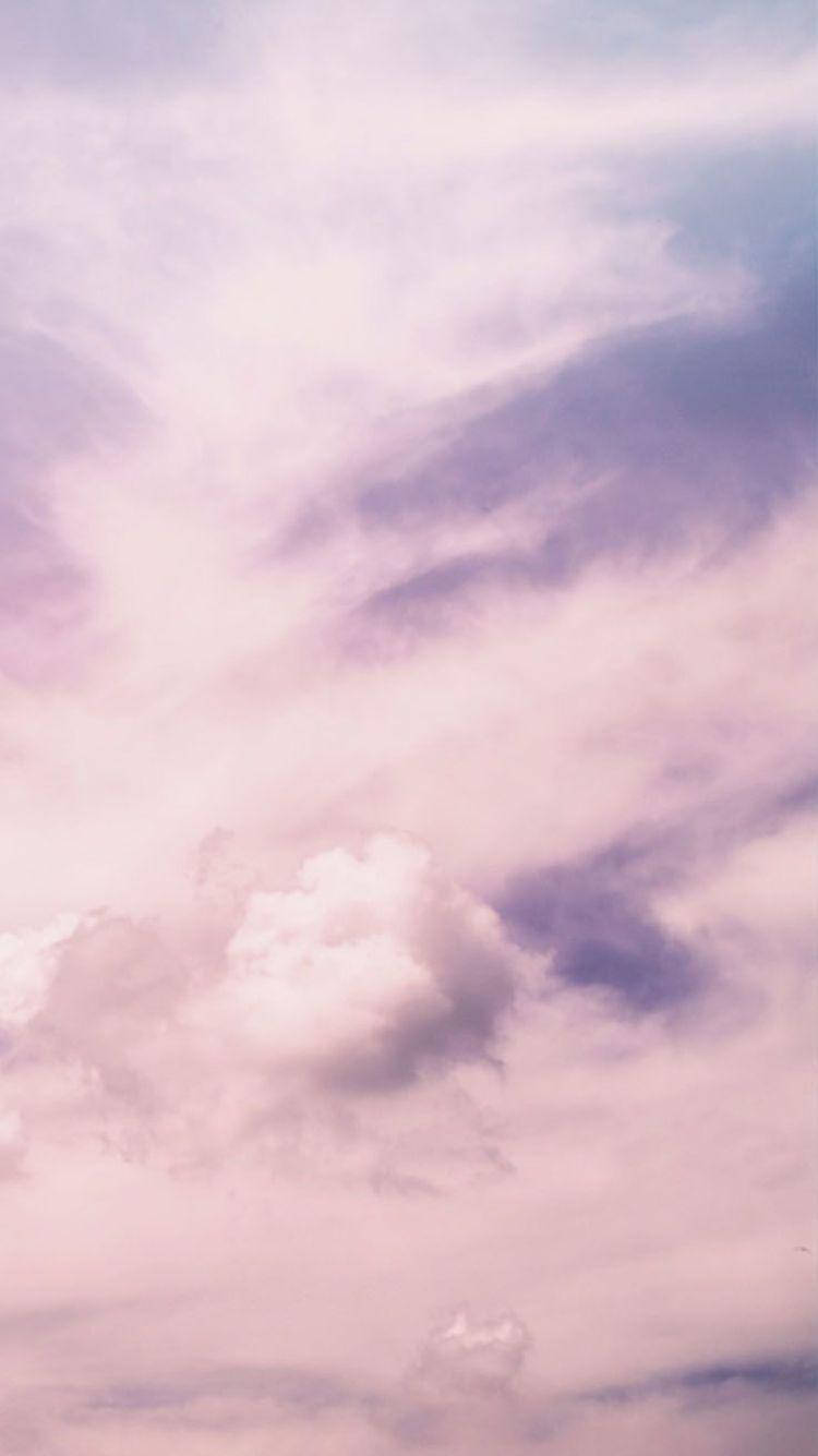 粉彩粉紅和紫色雲朵在寧靜的天空中飄浮。