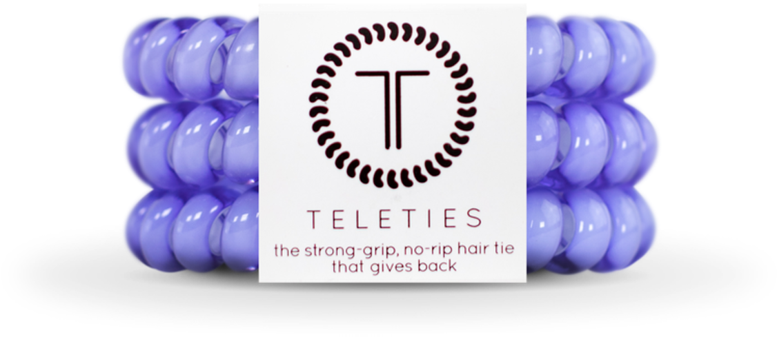 淡紫色Teleties髮圈 壁紙 — 紫色Teleties髮圈以對稱圖案圍繞帶有品牌標誌和標語的白色標籤的產品照片。