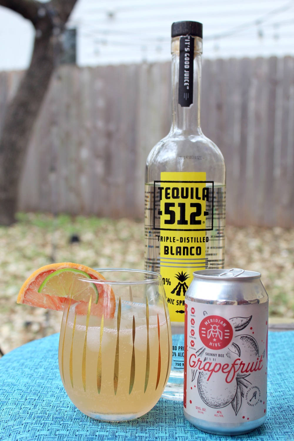 Tequila 512 白龍舌蘭酒搭配葡萄柚飲品 壁紙 — 一杯清爽的龍舌蘭雞尾酒配西柚梳打，旁邊放著一瓶Tequila 512，在藍色戶外桌上。