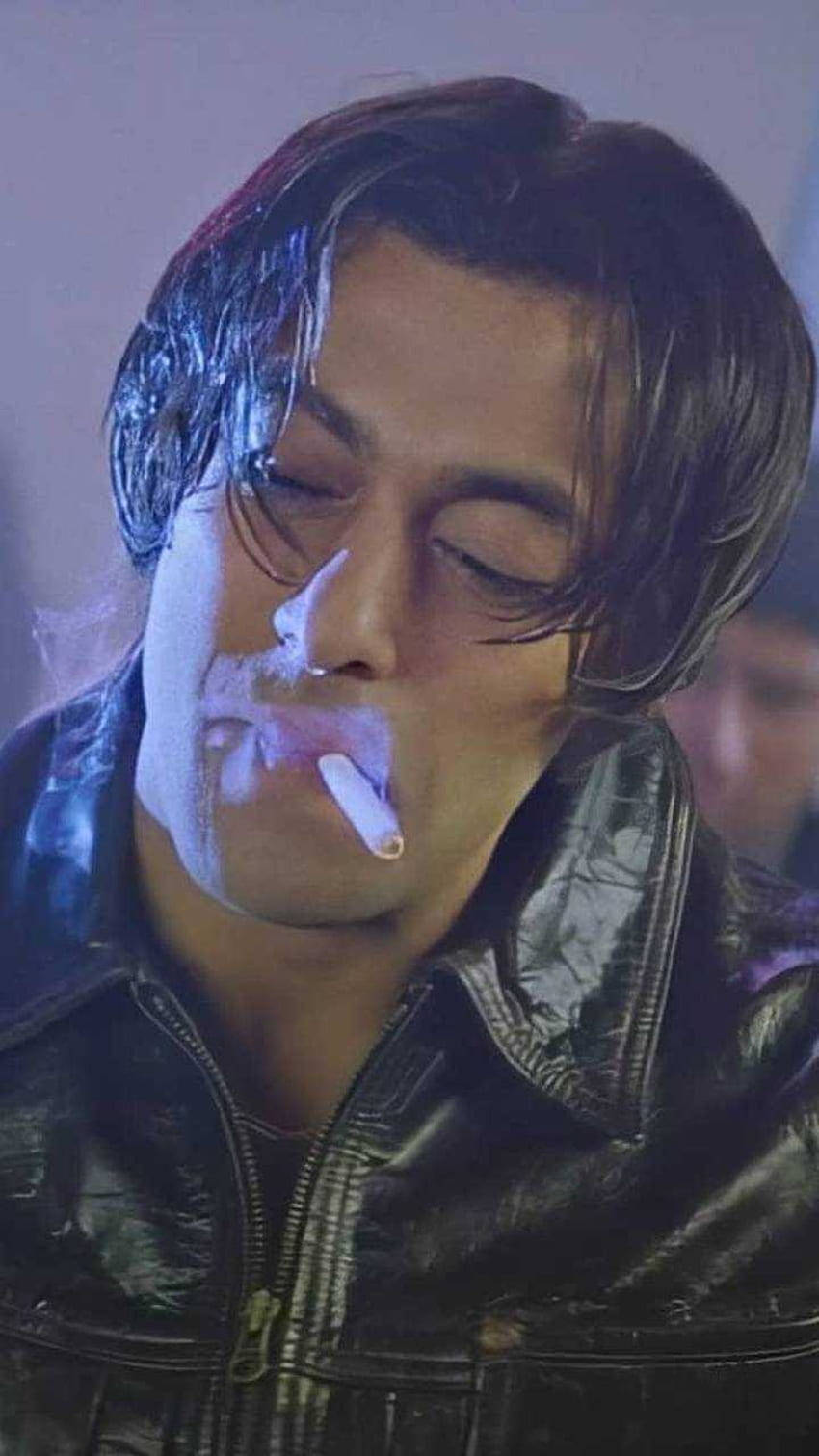 穿著皮褸的男人在昏暗藍光中閉著眼睛吸煙。