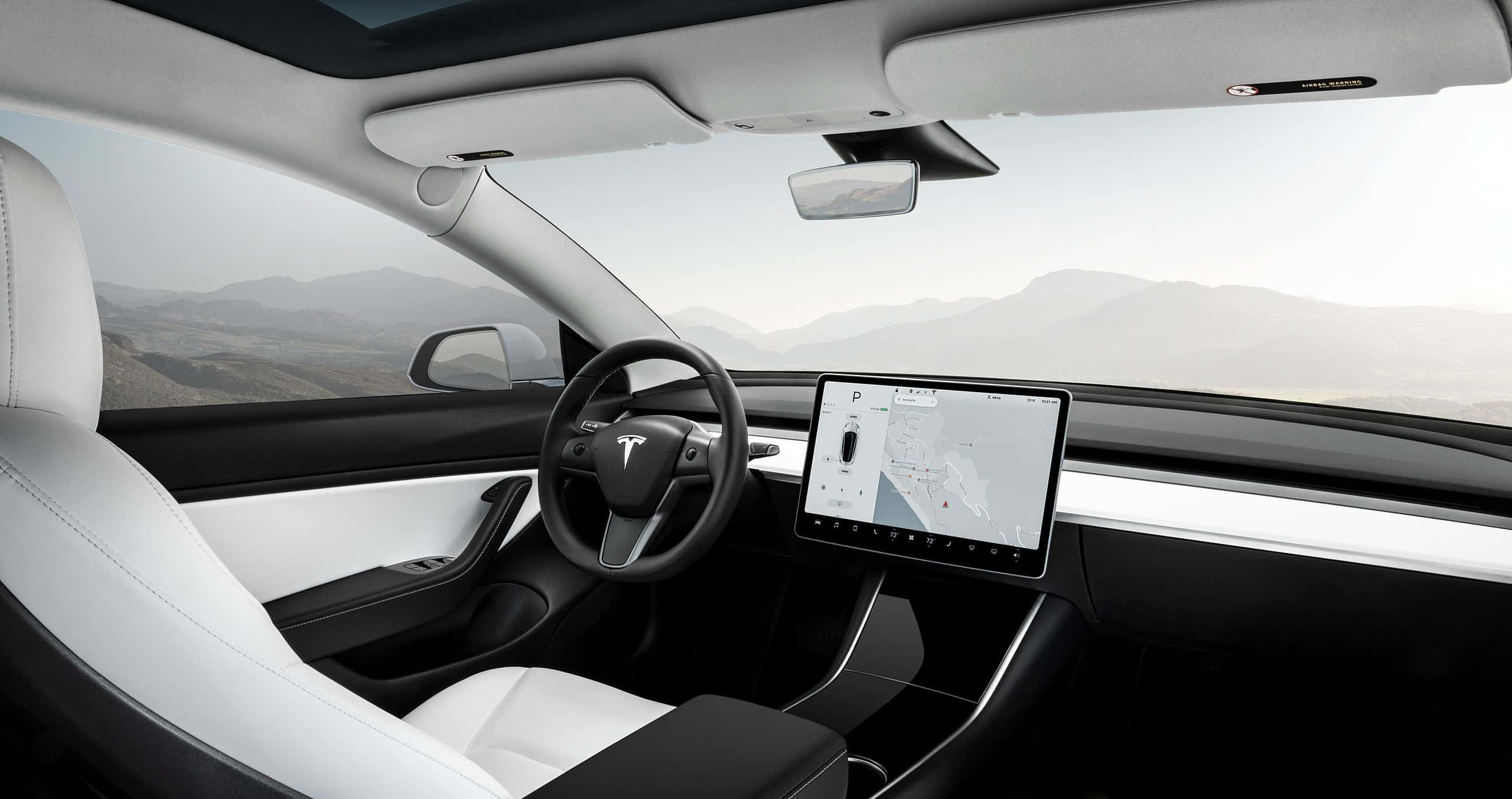 Minimalist Car 桌布 壁紙 — Tesla 車廂內部，配有白色皮革座椅和大型觸控螢幕儀表板，俯瞰山區地形。