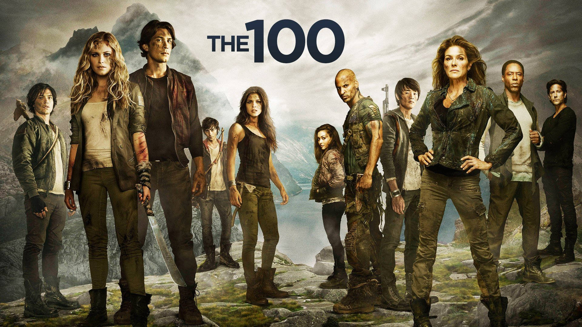 《The 100》的演員們站在一個反烏托邦背景的岩石山上。