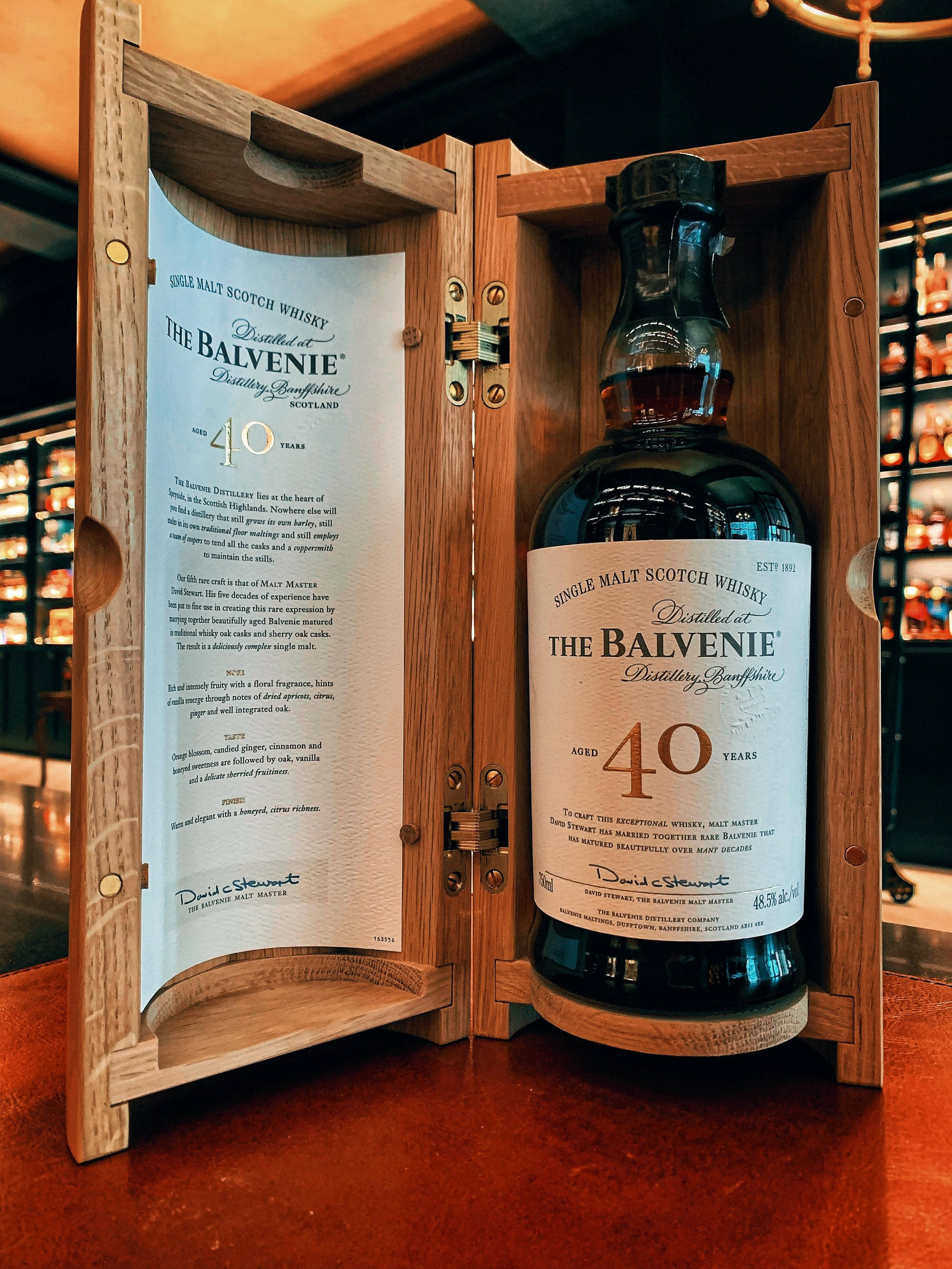 奢華品嚐：The Balvenie 40年威士忌 壁紙 — 一瓶奢華的40年The Balvenie單一麥芽威士忌，展示在其木製禮盒中，帶有詳細的標籤文字。