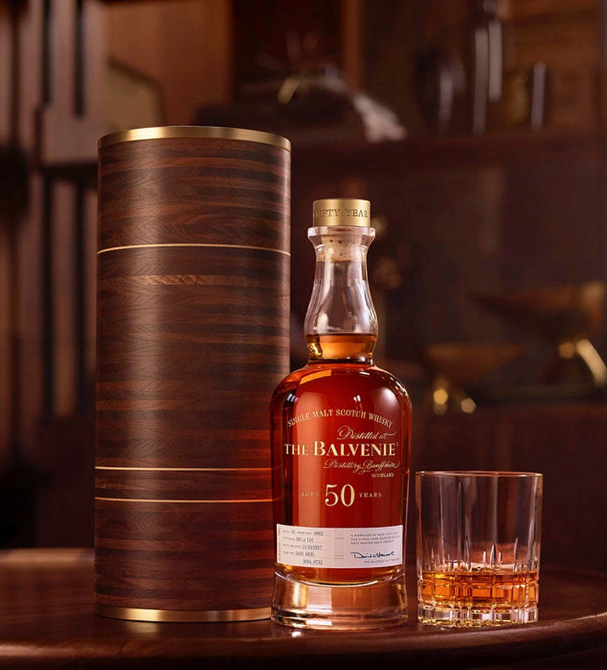 吧枱上的一瓶50年Balvenie威士忌，附有酒杯和木管。