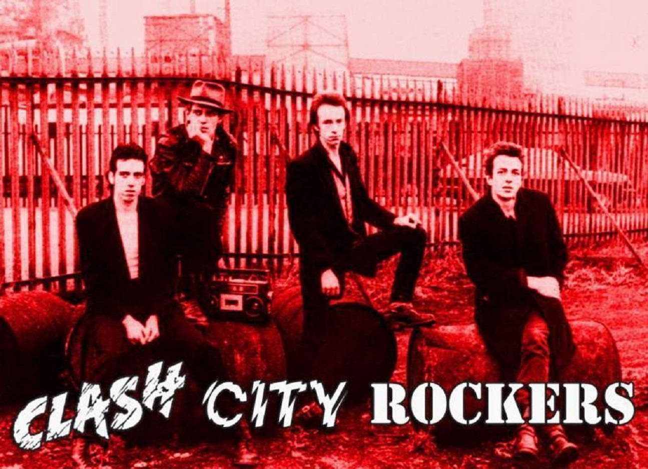 The Clash《City Rockers》專輯封面 壁紙 — 四個穿著黑色西裝和帽子的龐克搖滾歌手坐在桶上，背景是紅色調的圍欄，帶有手提音響和粗體文字。