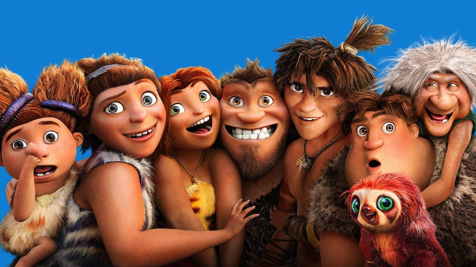The Croods 家族擁抱 — 溫暖的團聚時刻 壁紙 — 一群充滿活力的動畫史前角色，表情豐富，穿著毛茸茸的衣服，在純藍色背景前一起擺姿勢。