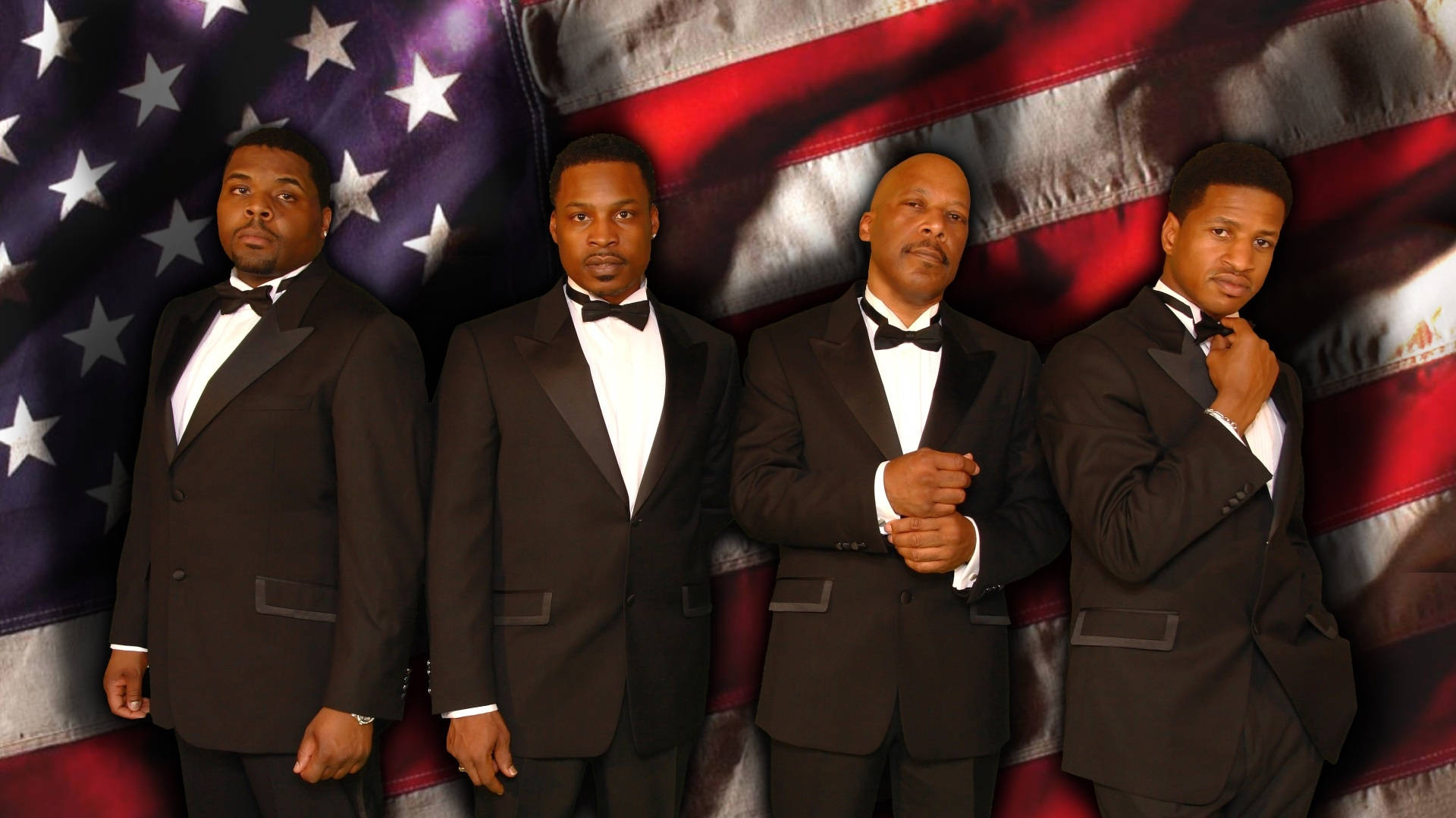 The Drifters 2008 Sacrifice 巡迴演唱會海報 壁紙 — 四個身穿黑色燕尾服的男人自信地站在有紋理的美國國旗背景前。