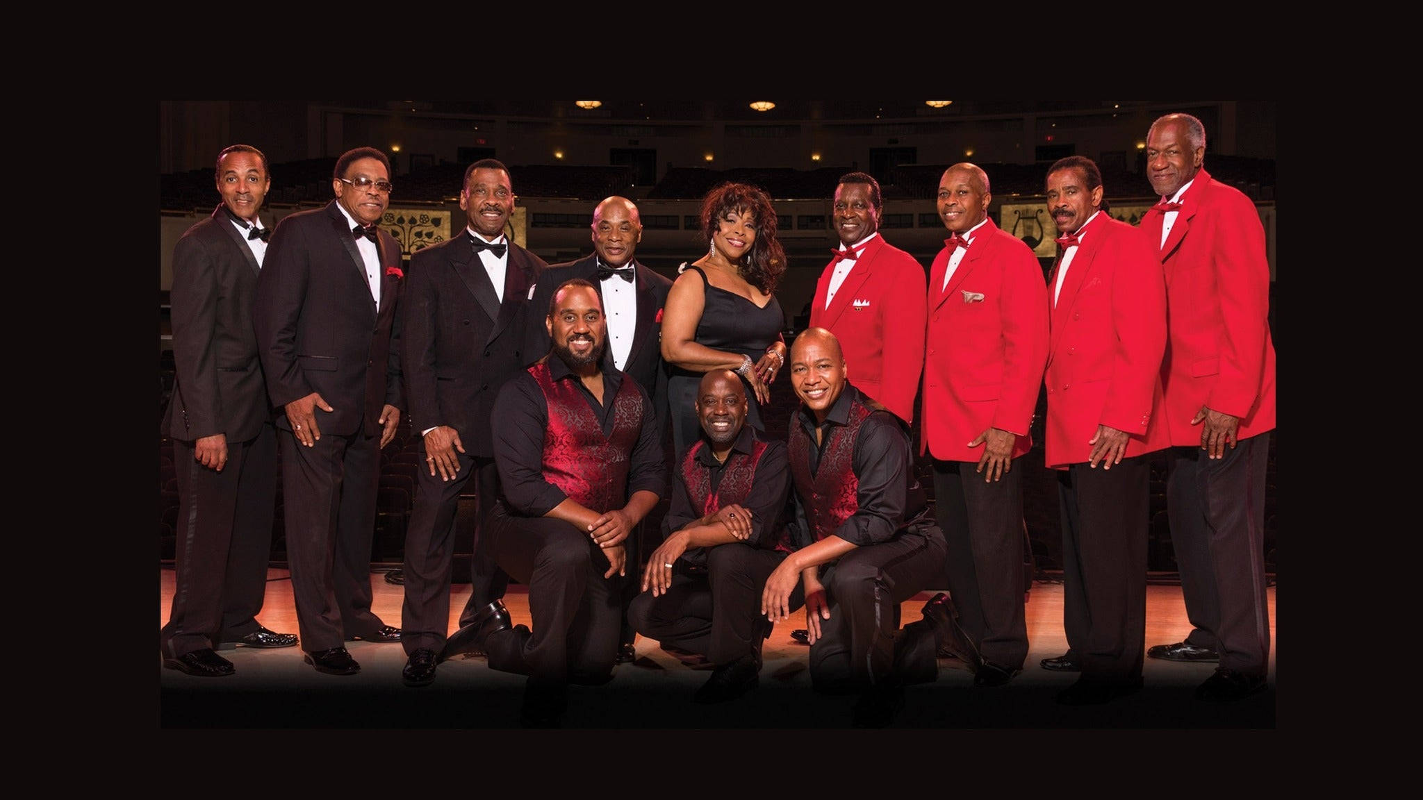 The Drifters、The Platters 與 The Cornell Gunter Coasters 舞台演出 壁紙 — 一對精心打扮的男女聲樂組合，身穿黑色燕尾服和紅色外套，在昏暗的舞台背景下正式擺姿勢。