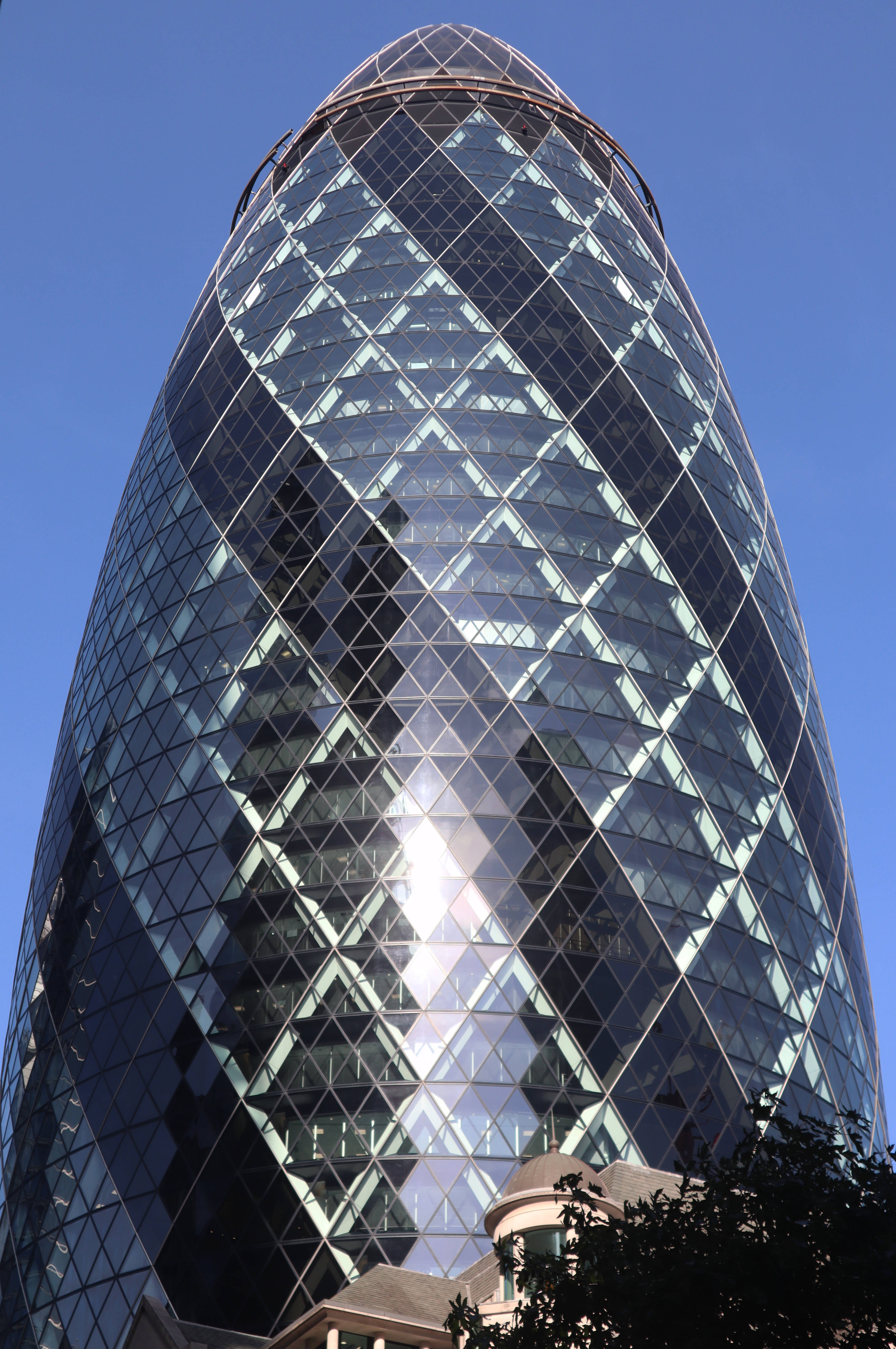 The Gherkin 玻璃彈頭 壁紙 — 一座高聳的玻璃摩天大樓，帶有獨特的弧形鑽石圖案外牆，在清澈的藍天下反射陽光。