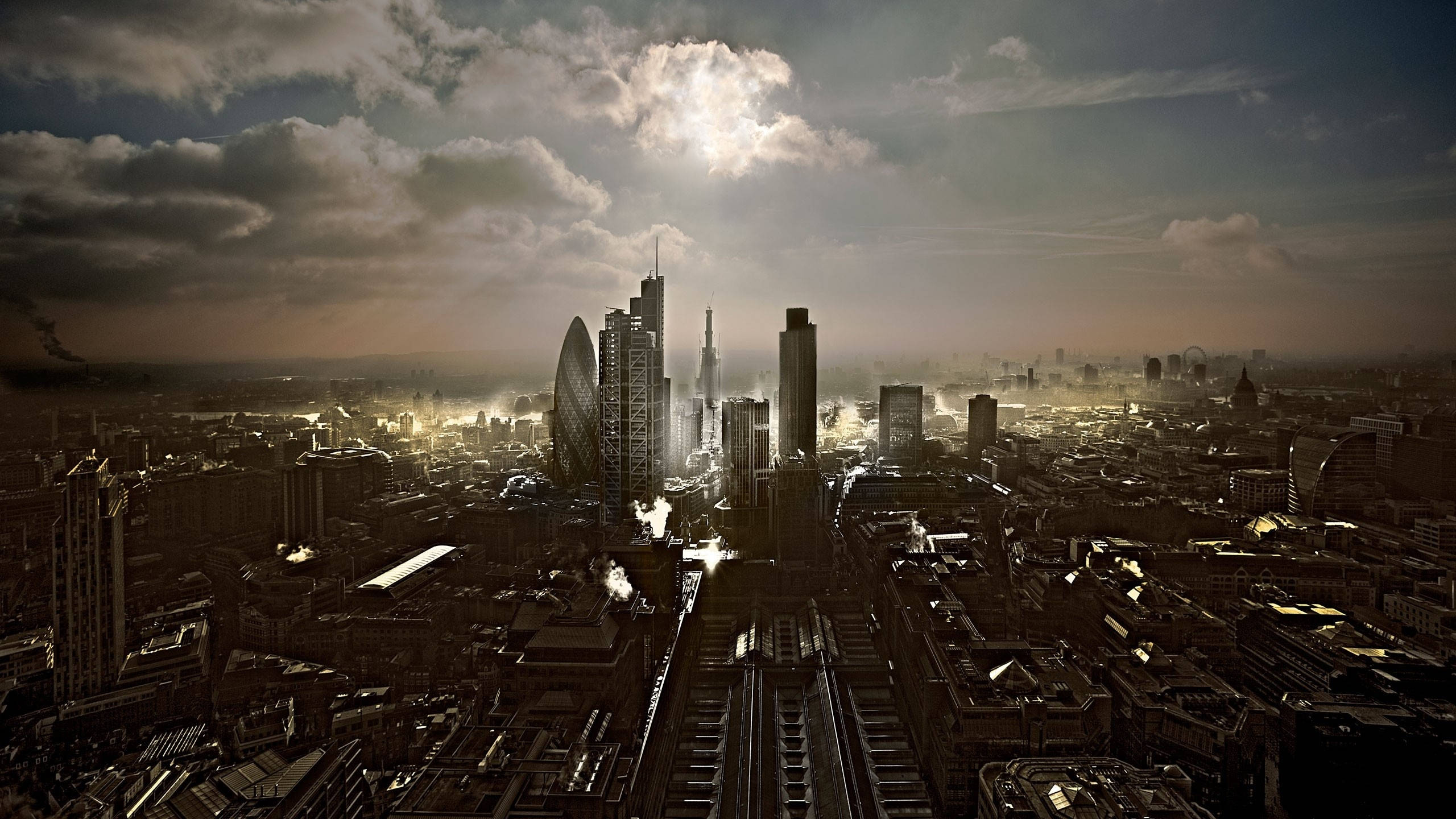 The Gherkin 空拍視角 壁紙 — 日落時分廣闊城市景觀的戲劇性航拍，金色光線穿過雲層，照耀在高聳的摩天大樓和密集的城市建築上。