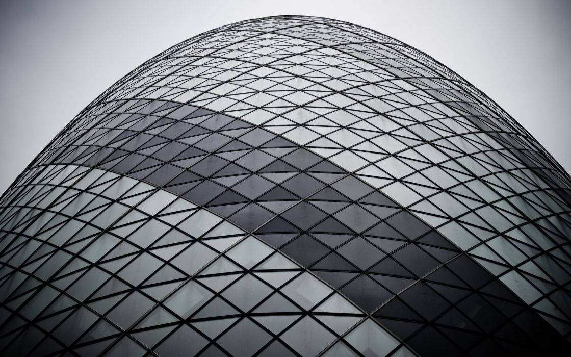 The Gherkin特寫 壁紙 — 從低角度觀看標誌性小黃瓜大廈的玻璃和鋼鐵外牆，天空多雲。