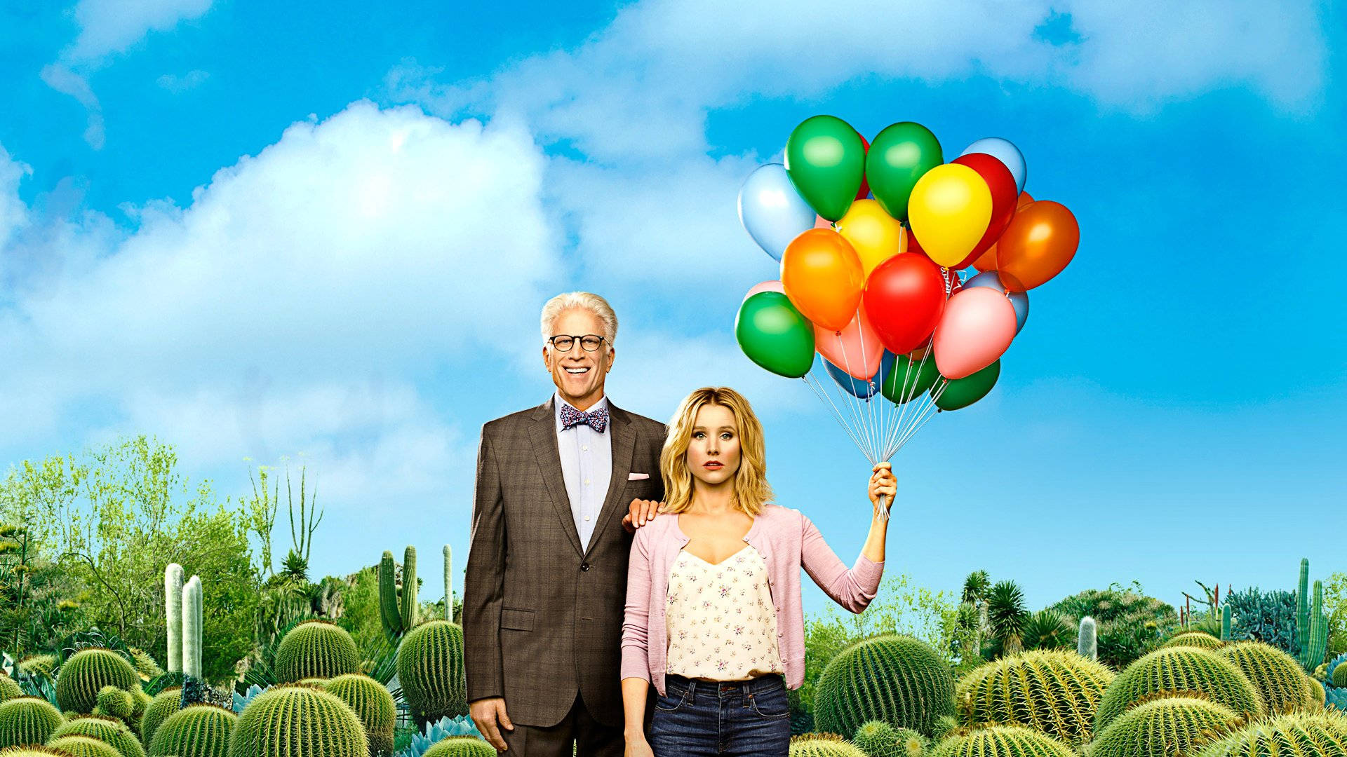 《The Good Place》愛蓮娜與肖恩於仙人掌田舉起彩色氣球 壁紙 — 一名男子和女子站在沙漠仙人掌田裡，在明亮的藍天下拿著一束色彩繽紛的氣球。