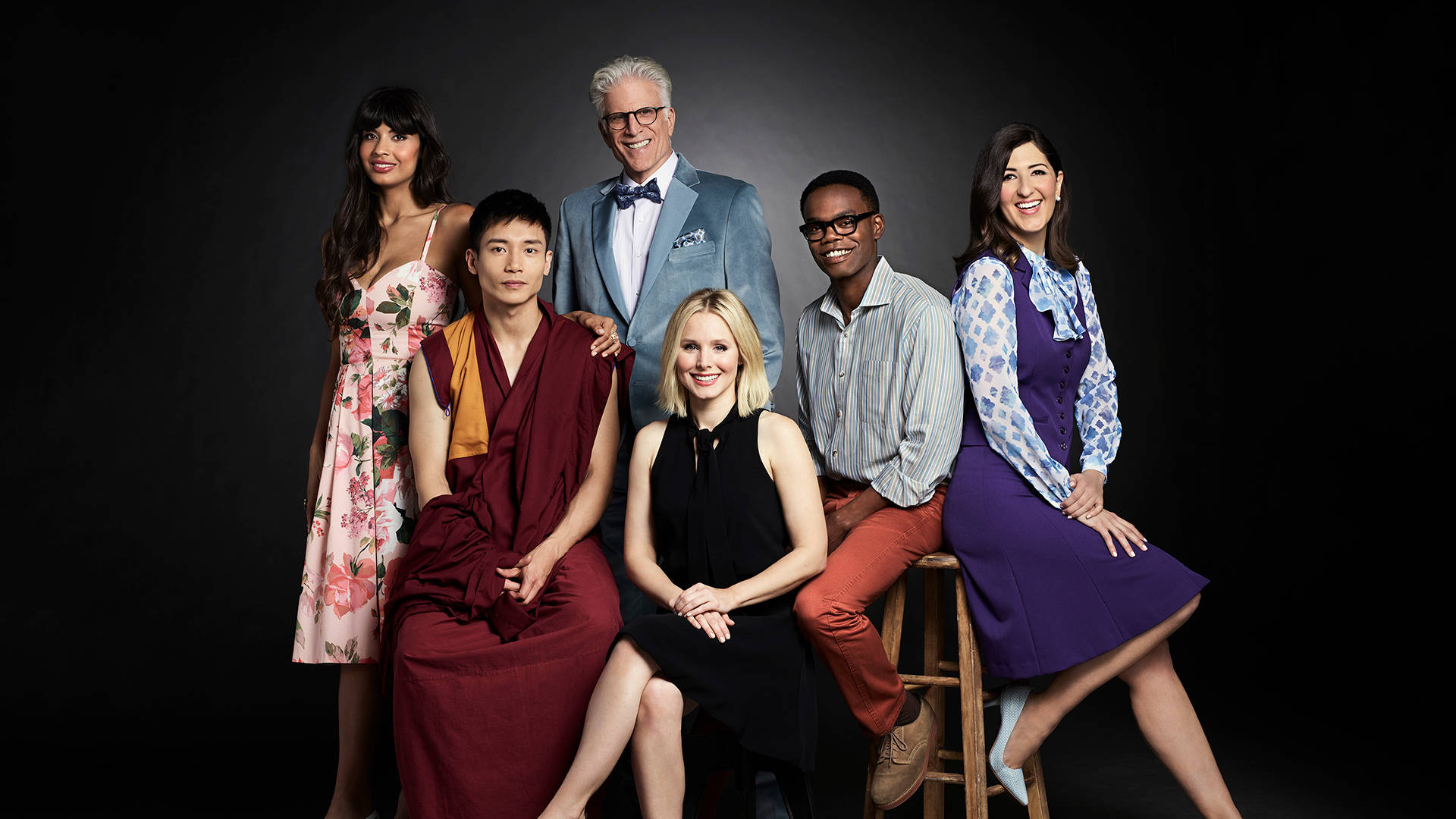 《The Good Place》角色室內攝影 壁紙 — 六位不同風格的人穿著時尚服裝，在柔和的燈光下，自信地擺姿勢於深色工作室背景前。
