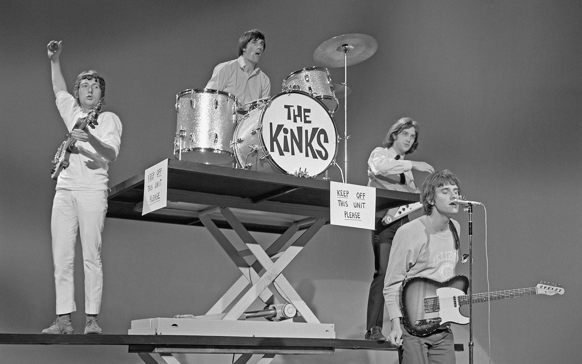 The Kinks《Shindig》專輯封面 壁紙 — The Kinks 在一個升高平台上表演，配有鼓組和結他，黑白照片。