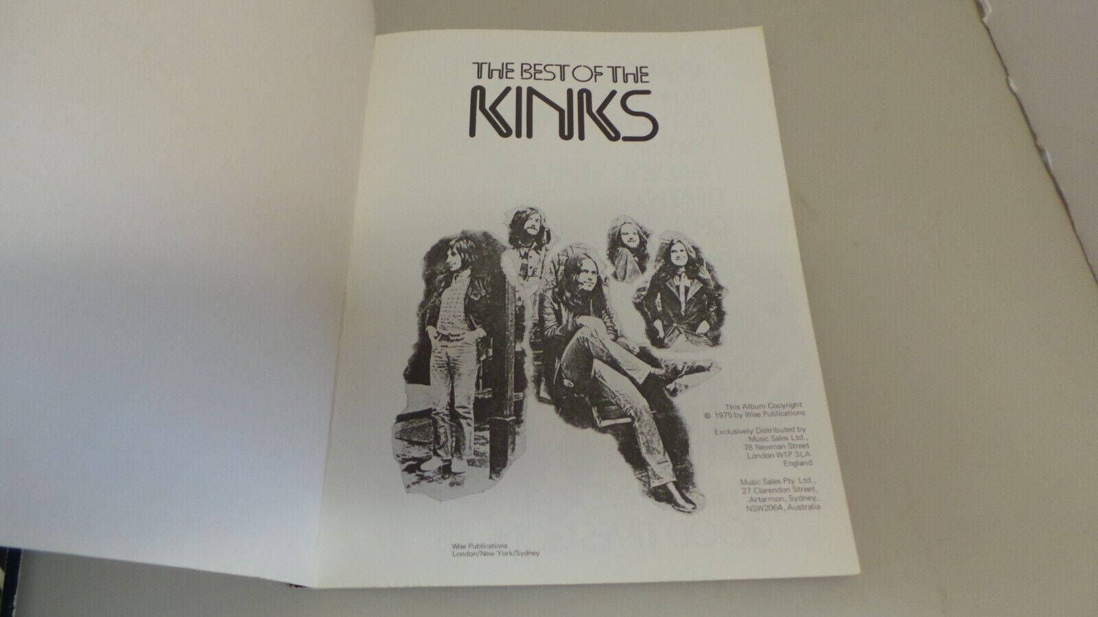 The Kinks《The Best Of》書頁 壁紙 — 一本為'The Best of The Kinks'而設的復古黑白專輯小冊子，打開放在平坦表面上，展示樂隊的插圖封面。