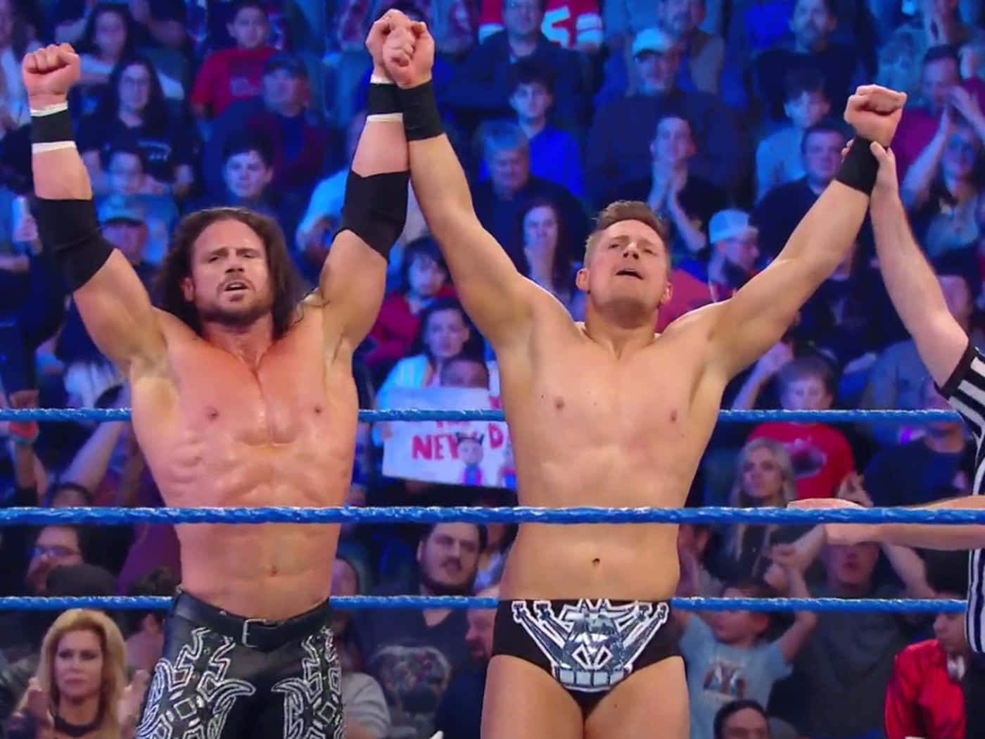 The Miz 勝利時刻 壁紙 — 兩名肌肉發達的摔角手在擂台上舉起拳頭慶祝勝利，歡呼的觀眾在觀看。