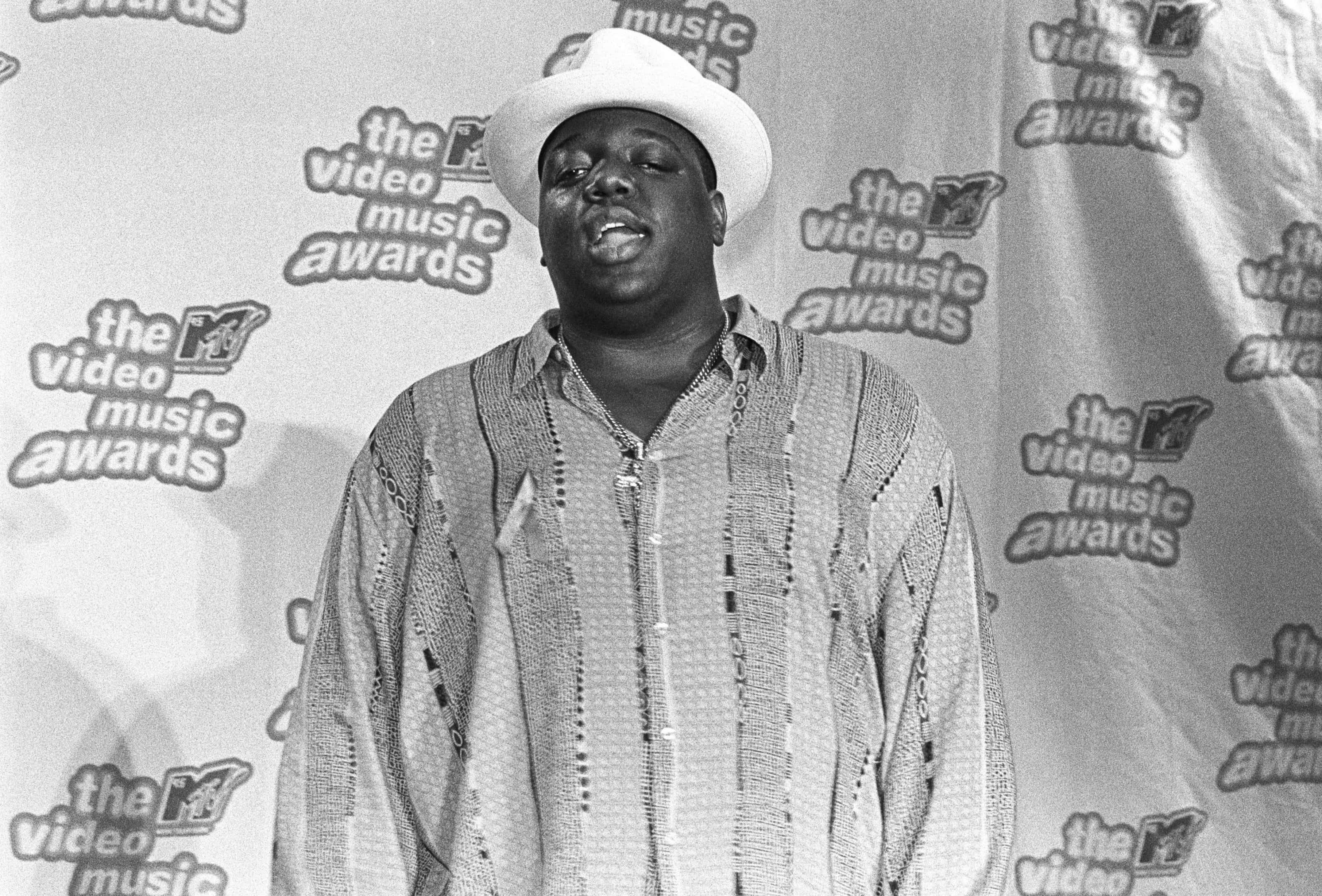 The Notorious B.I.G. 出席 1995 MTV 音樂錄影帶大獎 壁紙 — MTV Video Music Awards 上一位戴白色帽子和圖案襯衫的男士的黑白肖像。