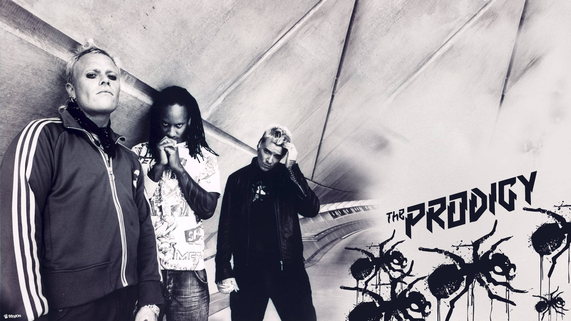 The Prodigy沿高速公路 壁紙 — The Prodigy 的三位樂隊成員在一個粗糙的隧道中擺姿勢，隧道內有塗鴉螞蟻和粗體樂隊名稱，黑白風格。
